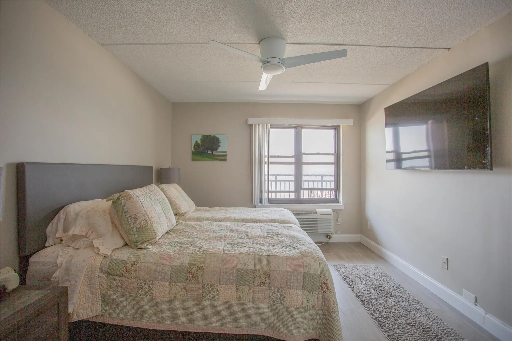 Bedroom with wood finished floors, a textured ceiling, and ceiling fan Bedroom with wood finished floors, a textured ceiling, and ceiling fan