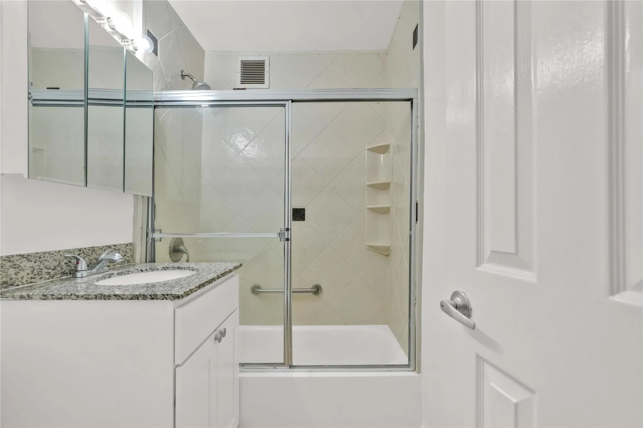 Bathroom featuring vanity and enclosed tub / shower combo Bathroom featuring vanity and enclosed tub / shower combo