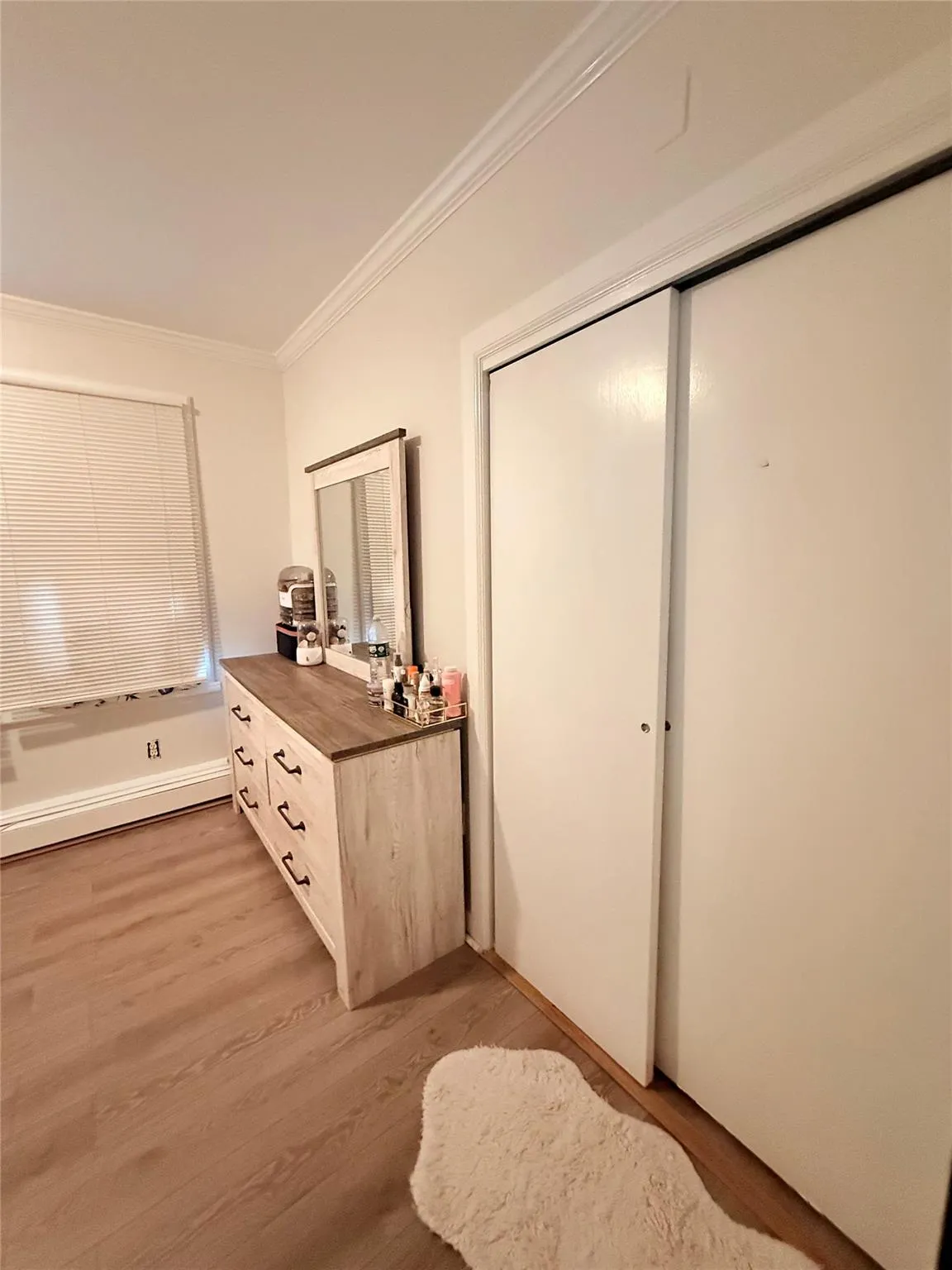 Hallway featuring crown molding and light wood-style floors Hallway featuring crown molding and light wood-style floors