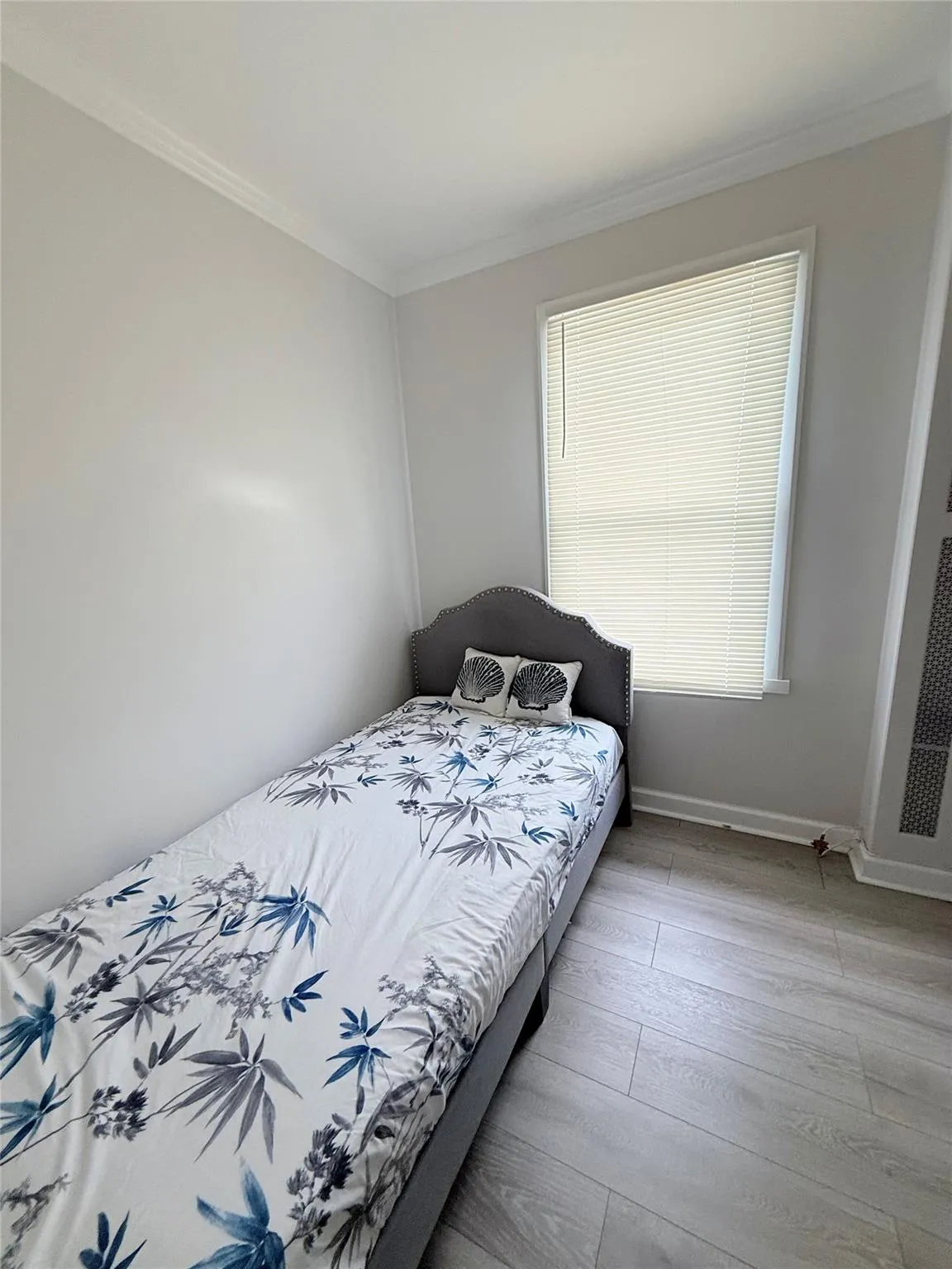 Bedroom with ornamental molding and wood finished floors Bedroom with ornamental molding and wood finished floors