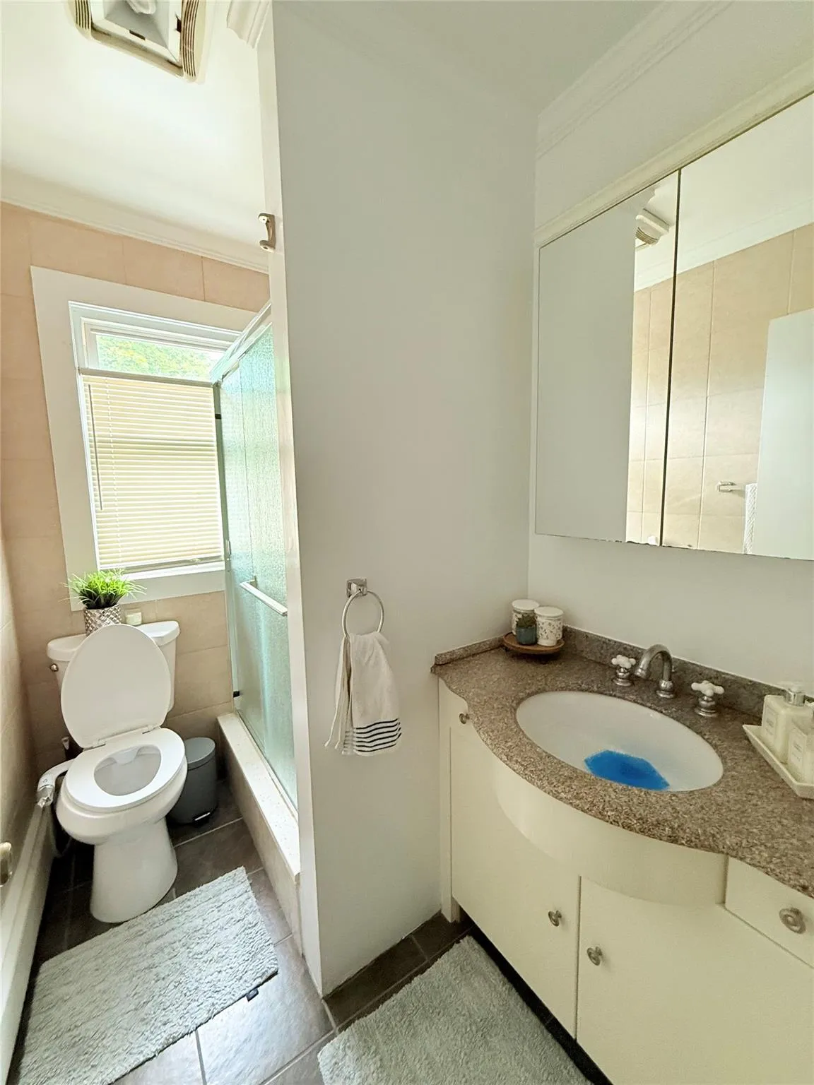 Bathroom with crown molding, a shower with shower door, vanity, and tile patterned flooring Bathroom with crown molding, a shower with shower door, vanity, and tile patterned flooring