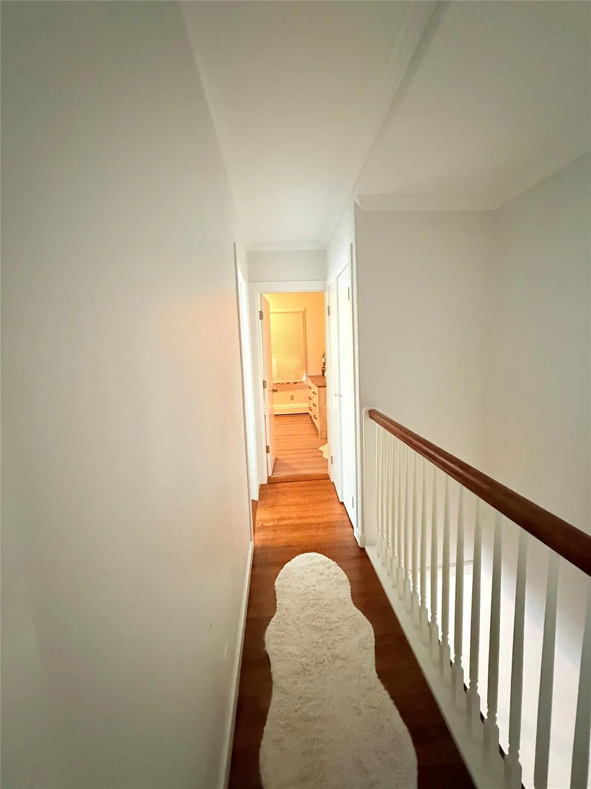 Hallway featuring wood finished floors and baseboards Hallway featuring wood finished floors and baseboards
