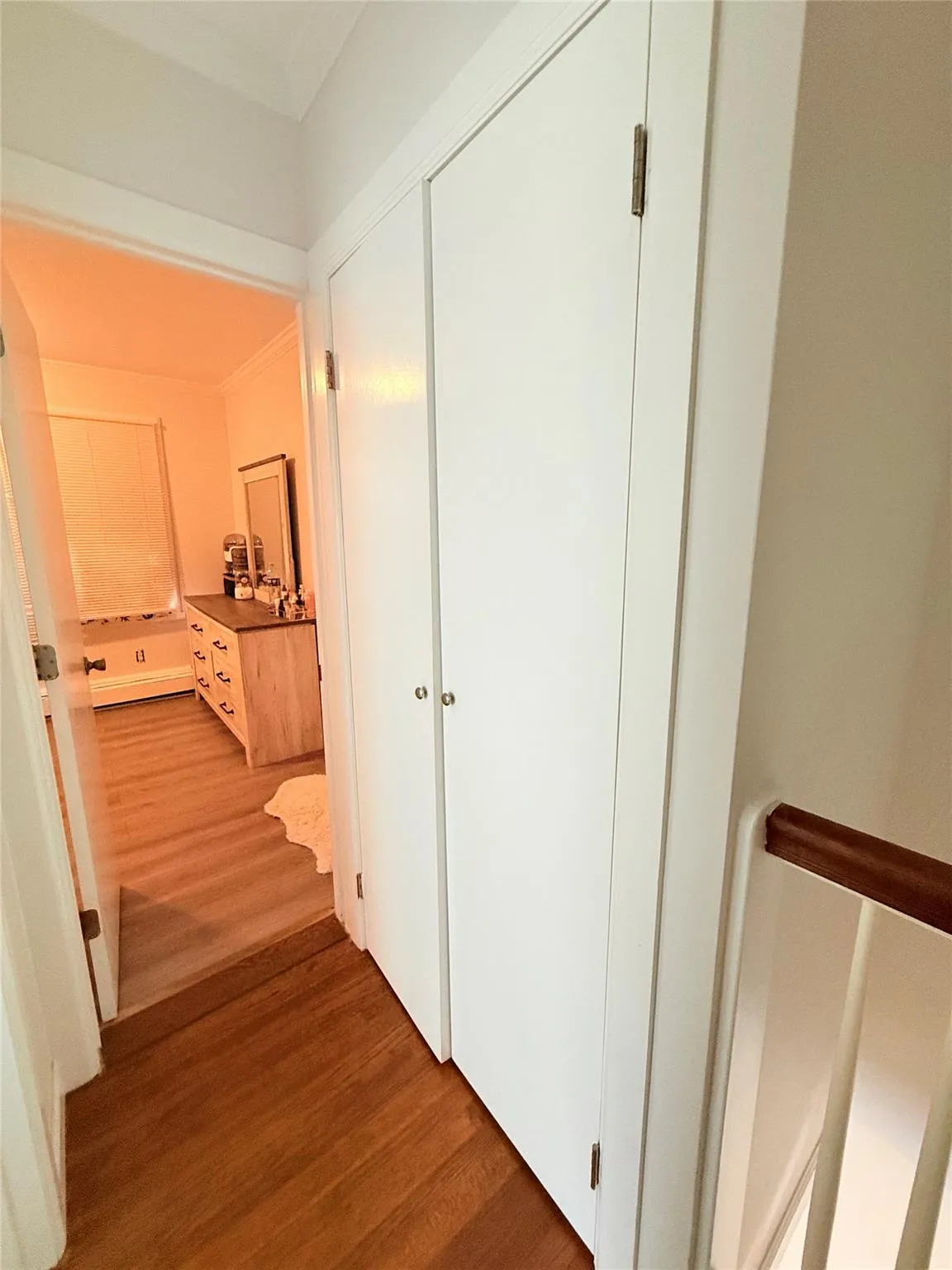 Hallway featuring wood finished floors and crown molding Hallway featuring wood finished floors and crown molding
