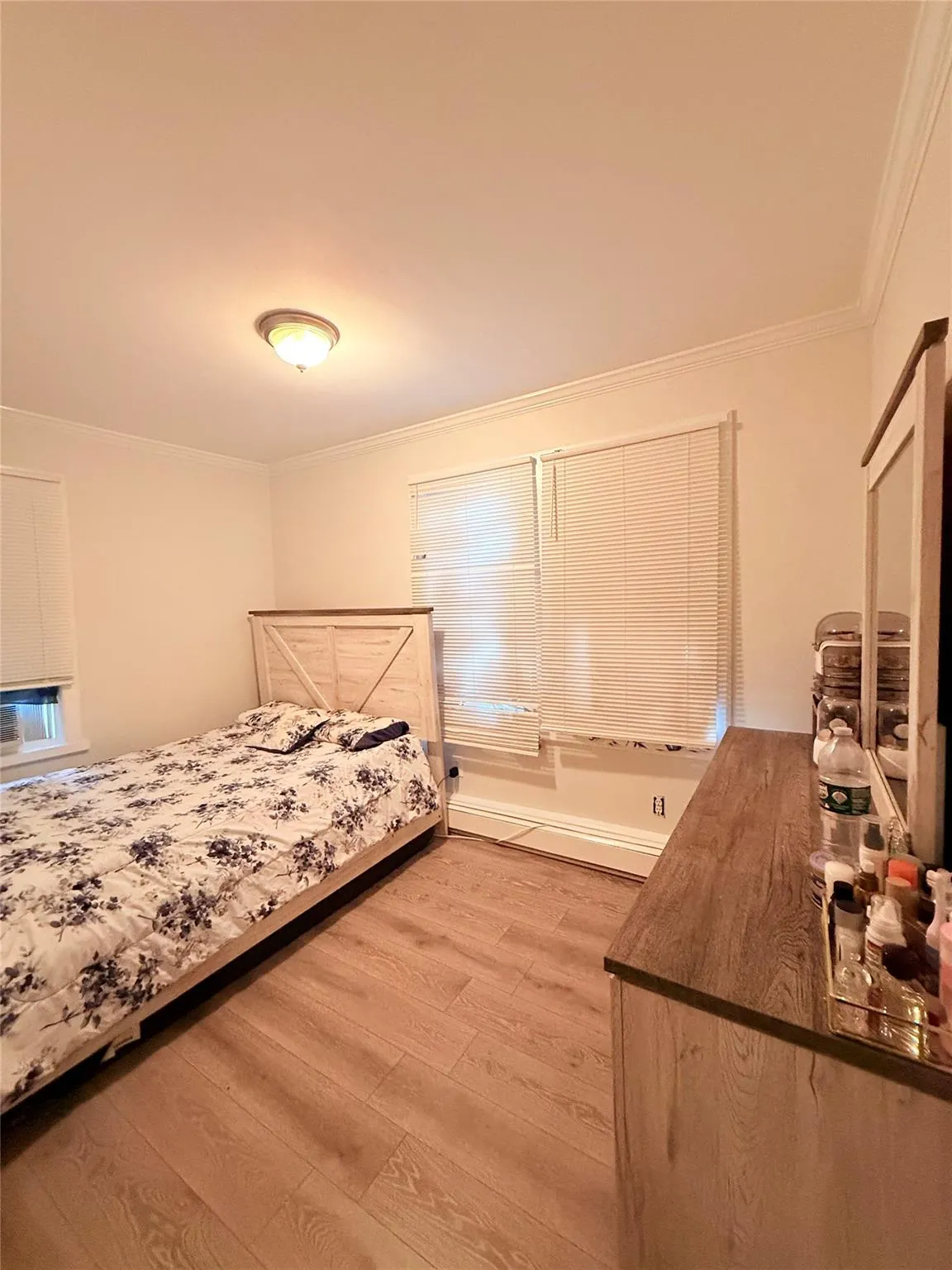 Bedroom with crown molding and light wood-type flooring Bedroom with crown molding and light wood-type flooring