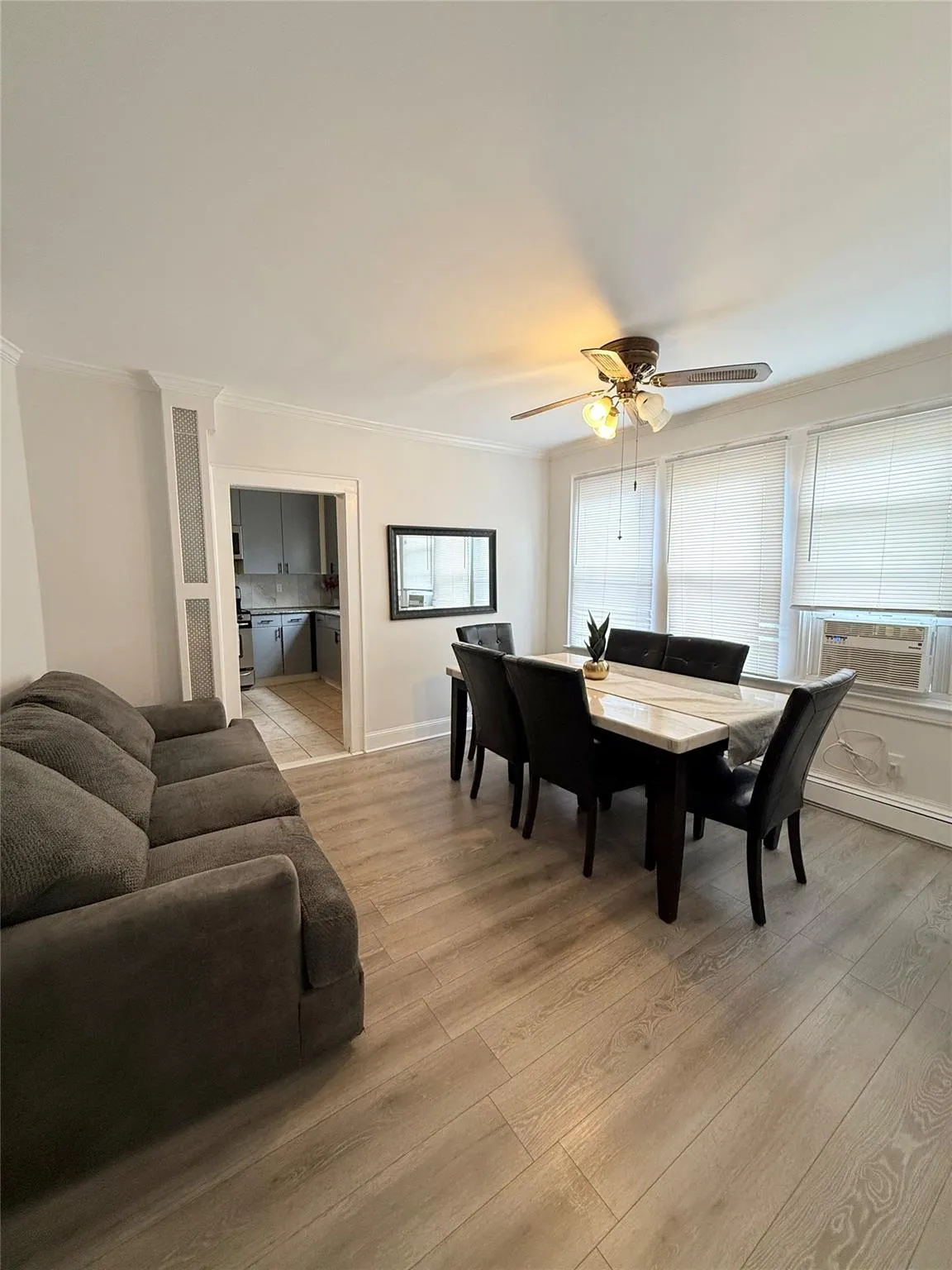 Dining area with ornamental molding, light wood finished floors, and ceiling fan Dining area with ornamental molding, light wood finished floors, and ceiling fan