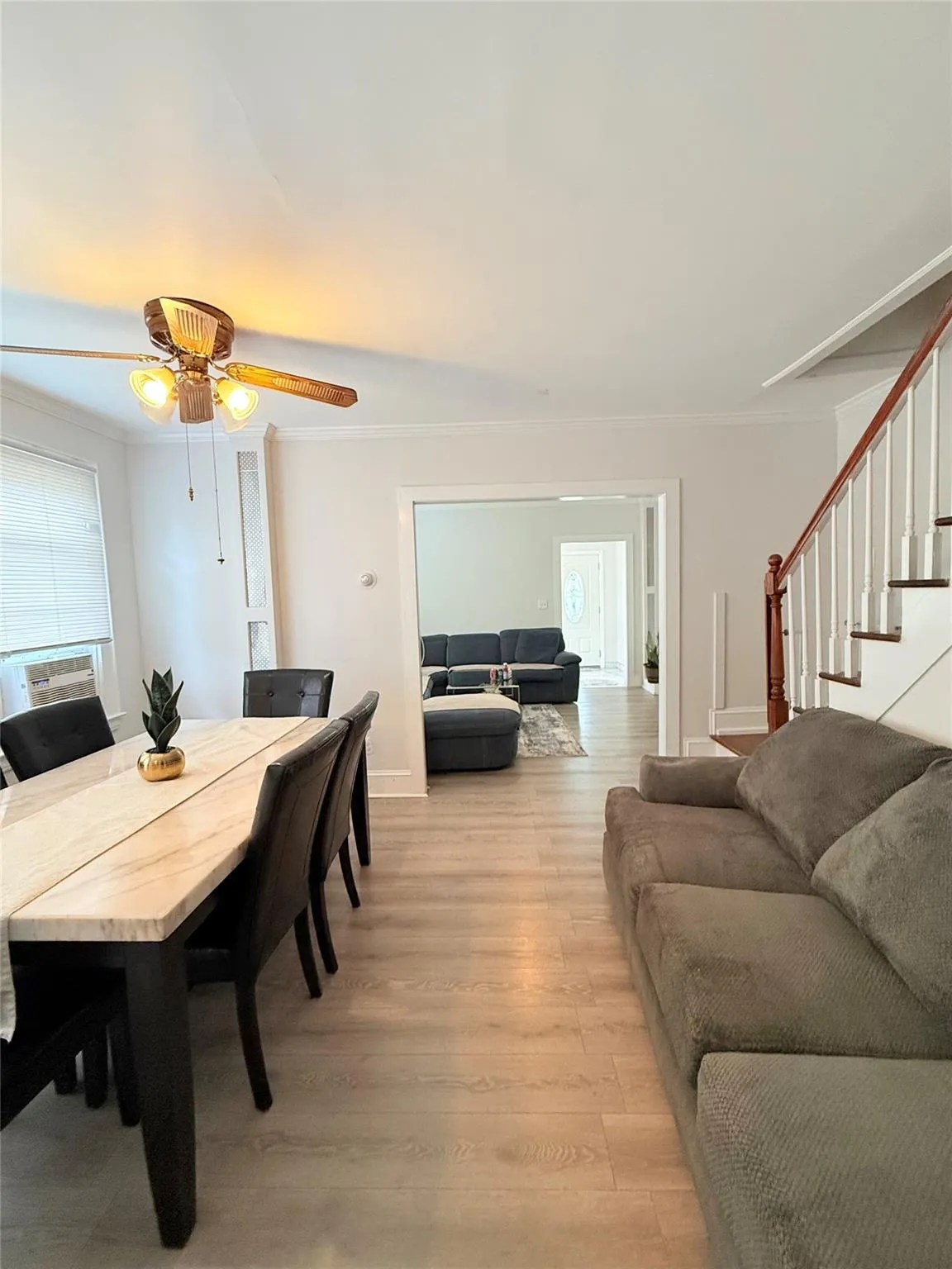 Dining area with crown molding, light wood-type flooring, stairs, and ceiling fan Dining area with crown molding, light wood-type flooring, stairs, and ceiling fan