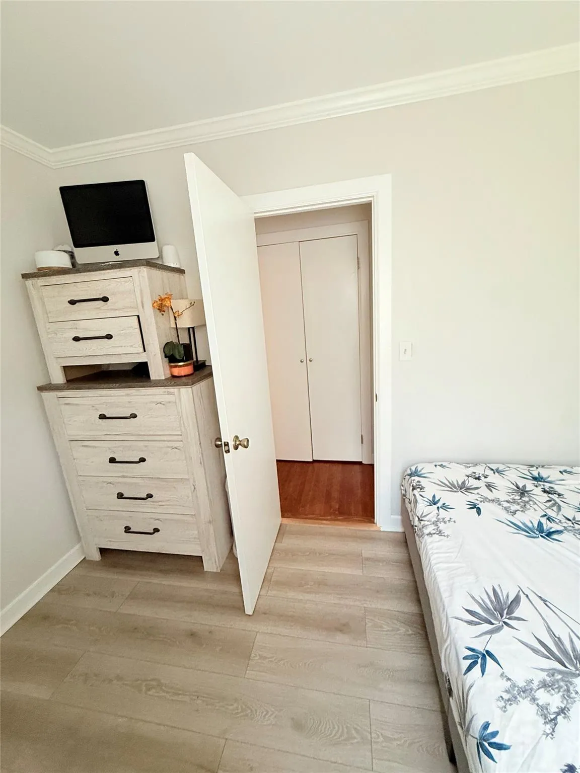 Bedroom with crown molding and light wood-type flooring Bedroom with crown molding and light wood-type flooring