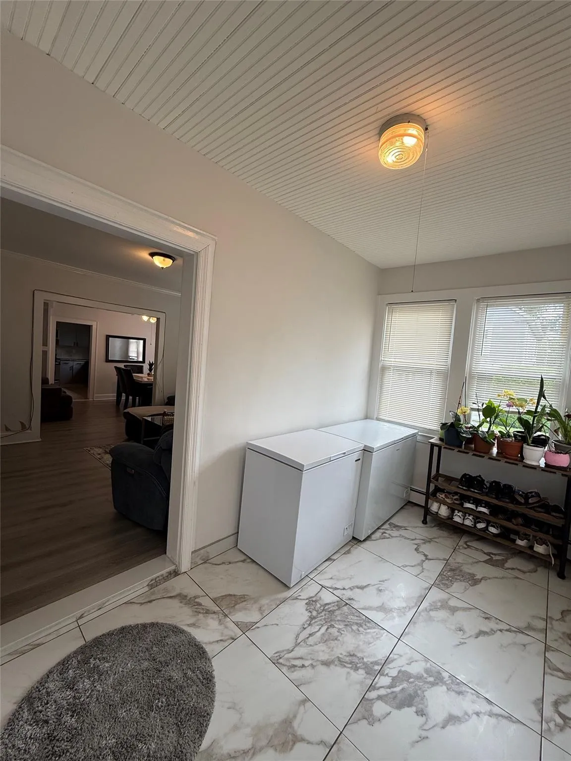 Laundry room featuring light marble finish floors and washing machine and clothes dryer Laundry room featuring light marble finish floors and washing machine and clothes dryer