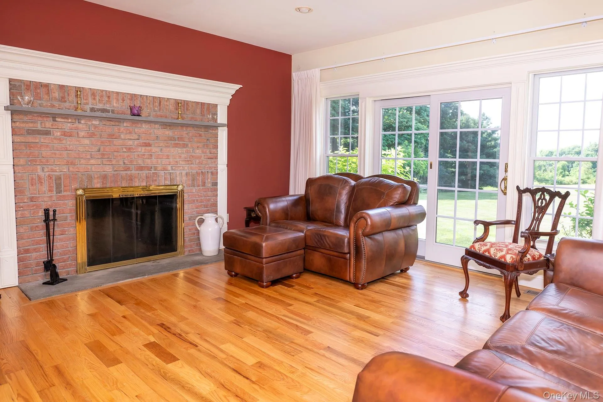 Family room off kitchen with brick fireplace and wall of windows to back yard Family room off kitchen with brick fireplace and wall of windows to back yard