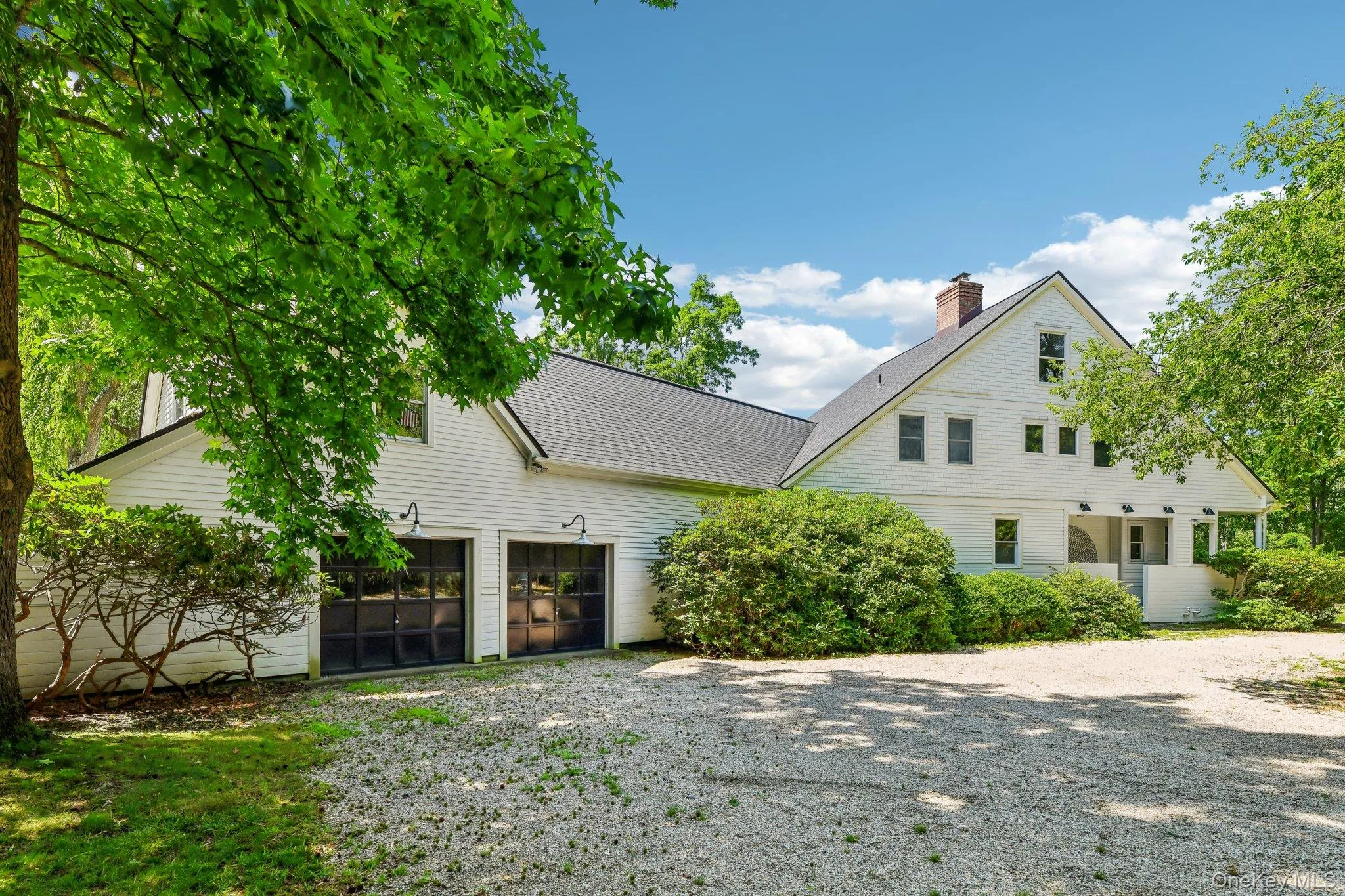View of front of house featuring a shingled roof, a chimney, and gravel driveway View of front of house featuring a shingled roof, a chimney, and gravel driveway