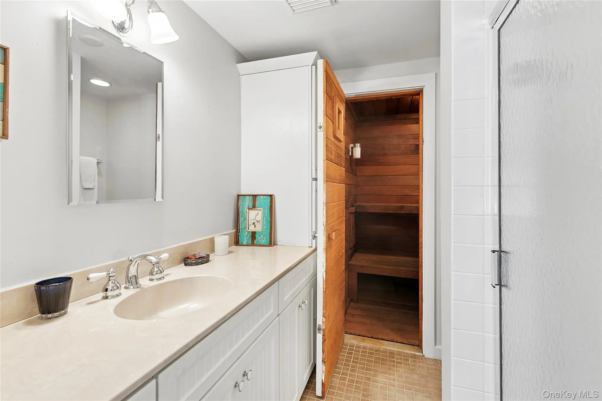 Bathroom with vanity, light tile patterned floors, a sauna, and a stall shower Bathroom with vanity, light tile patterned floors, a sauna, and a stall shower