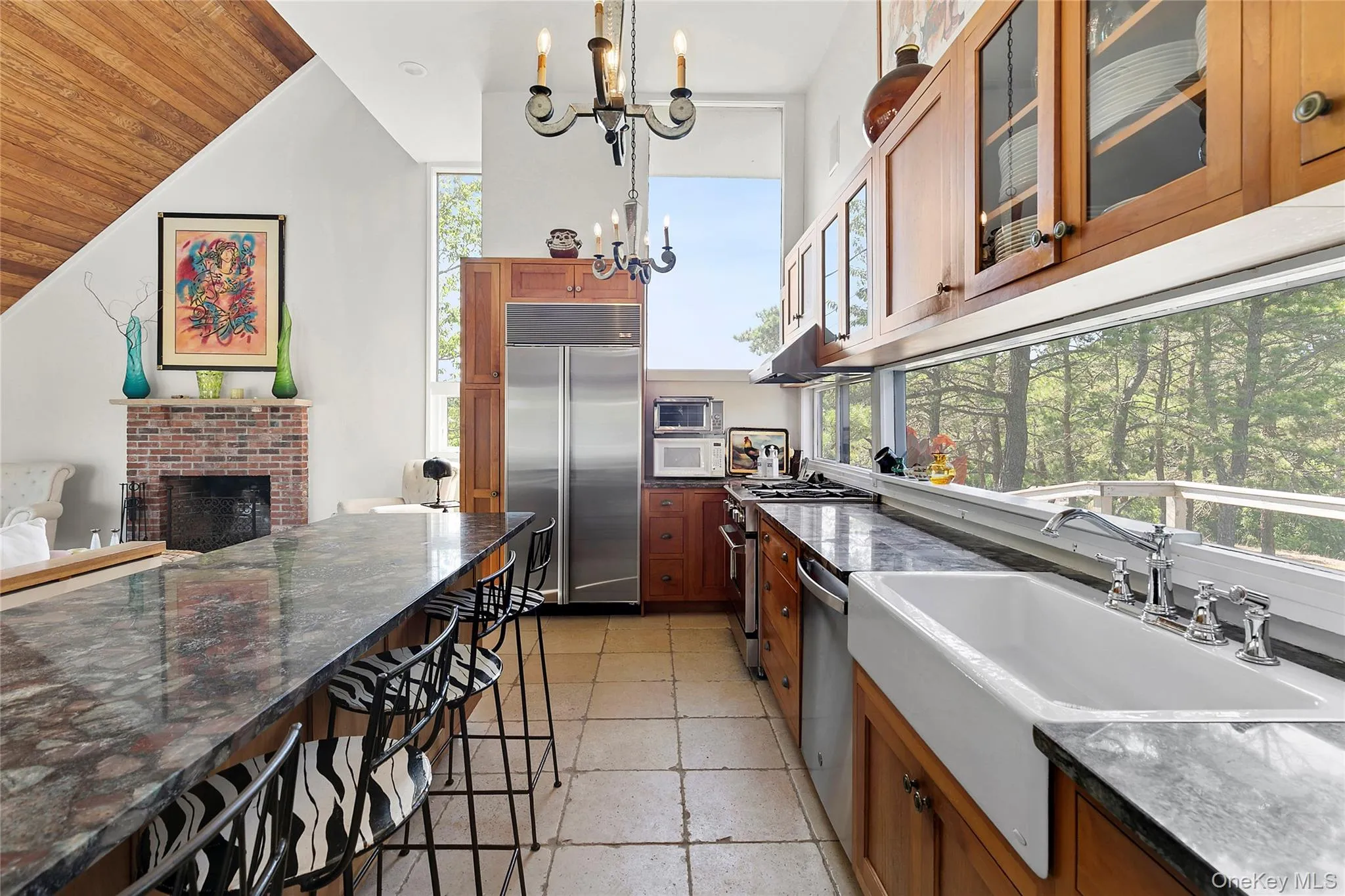 Kitchen with brown cabinetry, glass insert cabinets, high end appliances, dark stone countertops, and wood ceiling Kitchen with brown cabinetry, glass insert cabinets, high end appliances, dark stone countertops, and wood ceiling