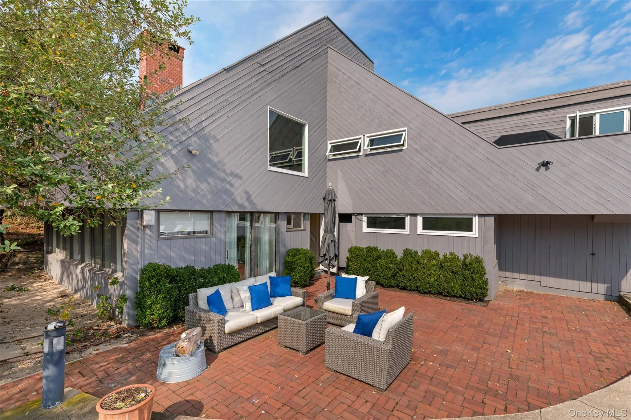 Back of house featuring outdoor lounge area, a patio area, and a chimney Back of house featuring outdoor lounge area, a patio area, and a chimney