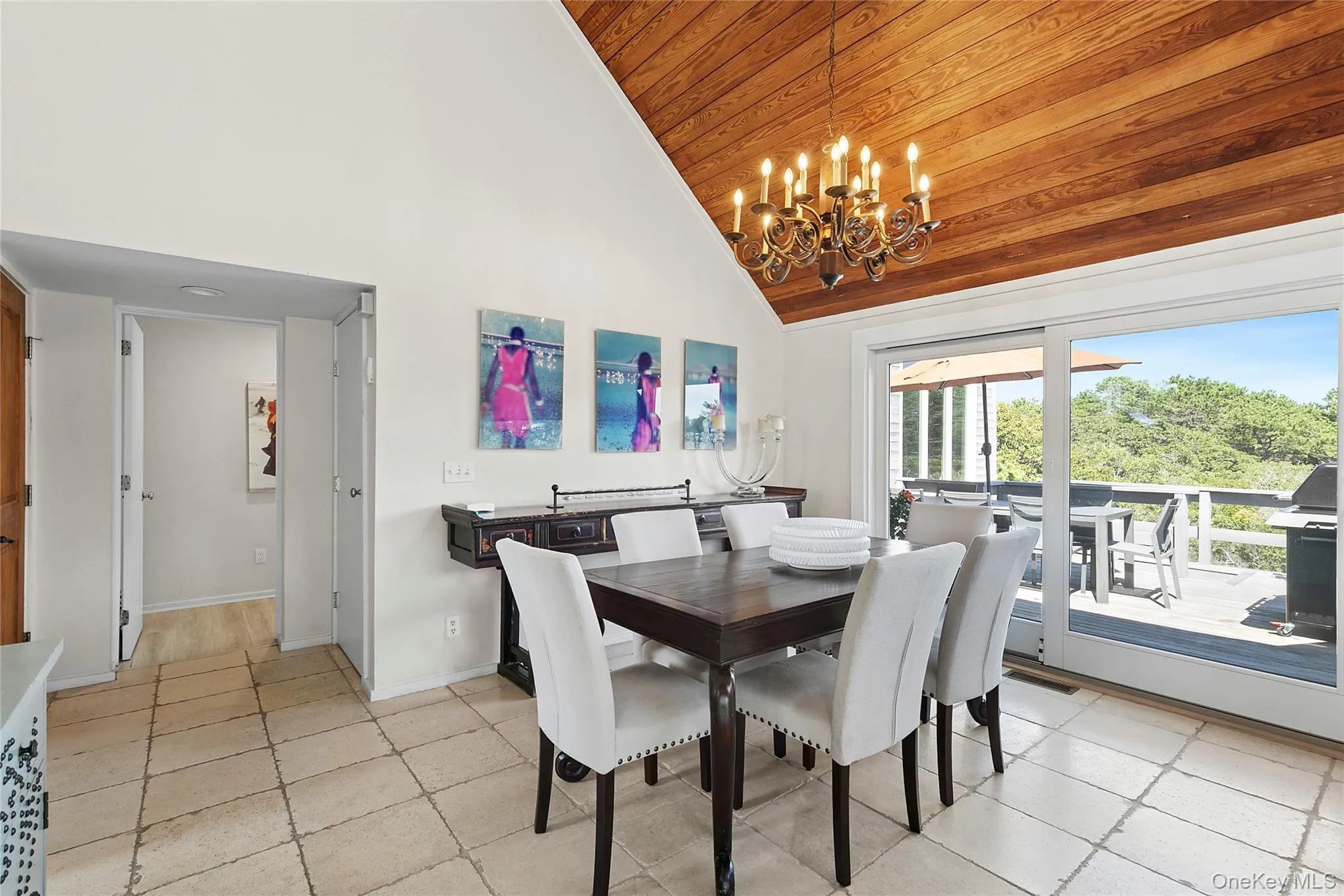 Dining room with high vaulted ceiling, wood ceiling, a chandelier, and light tile patterned flooring Dining room with high vaulted ceiling, wood ceiling, a chandelier, and light tile patterned flooring