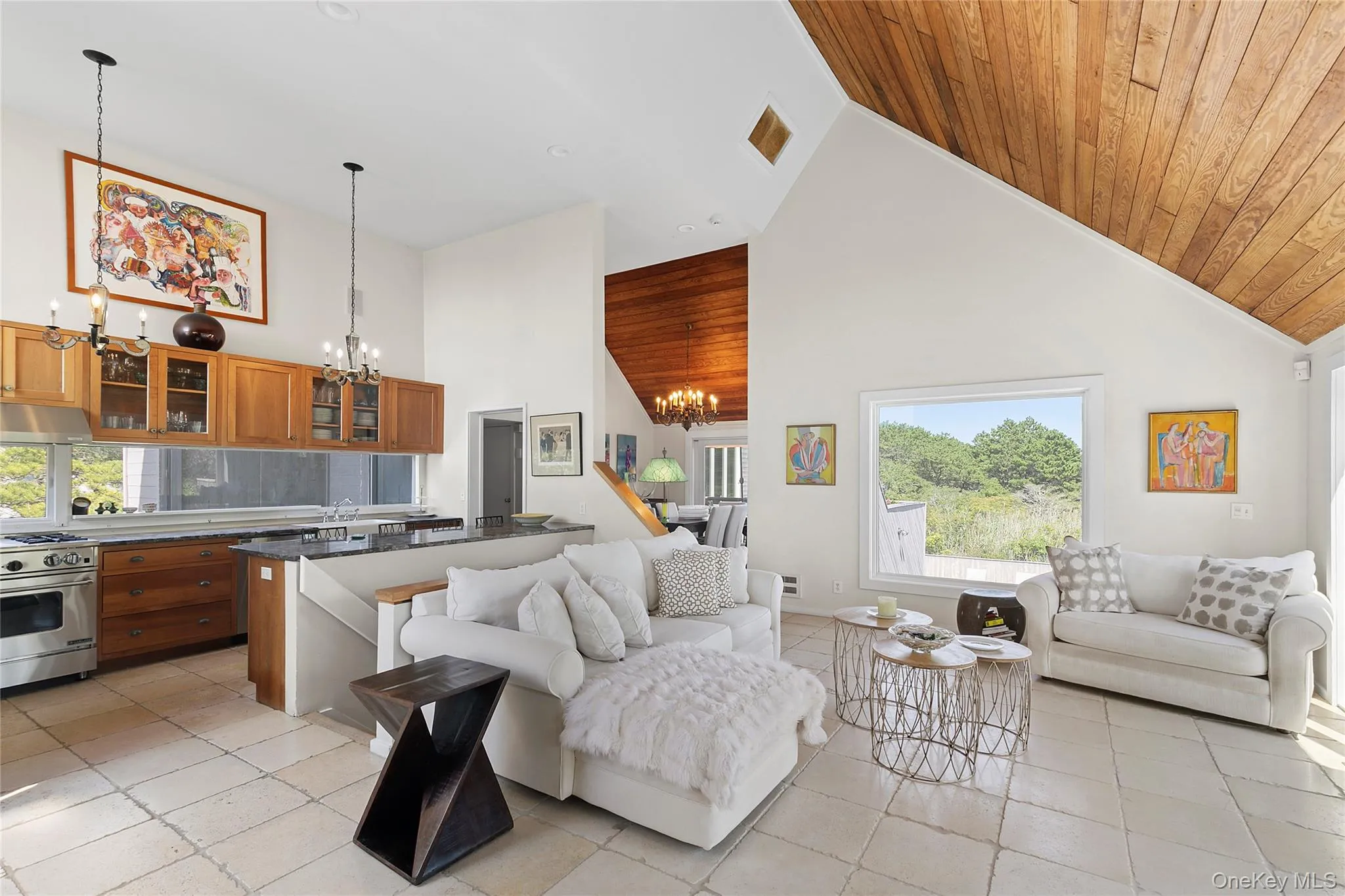 Living area with high vaulted ceiling, a chandelier, light tile patterned floors, and wooden ceiling Living area with high vaulted ceiling, a chandelier, light tile patterned floors, and wooden ceiling