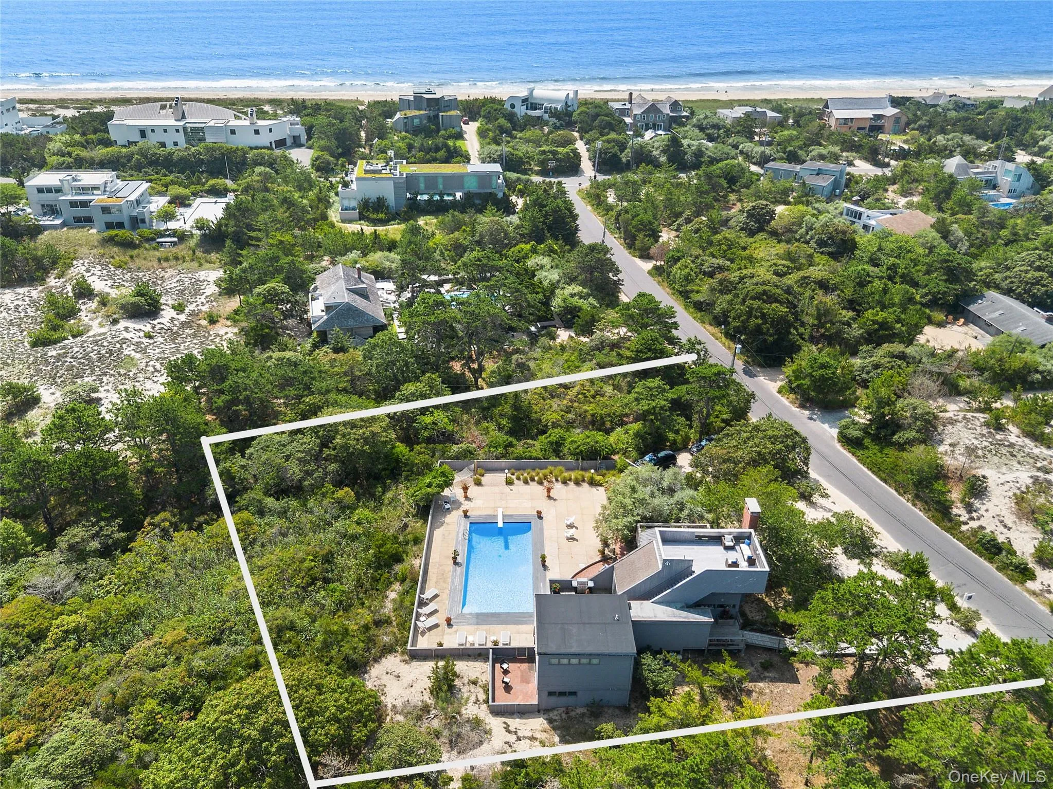 Aerial view of property and surrounding area featuring a pool and property boundaries highlighted Aerial view of property and surrounding area featuring a pool and property boundaries highlighted