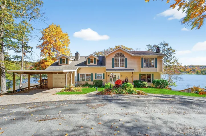 View of front of house featuring a chimney and driveway