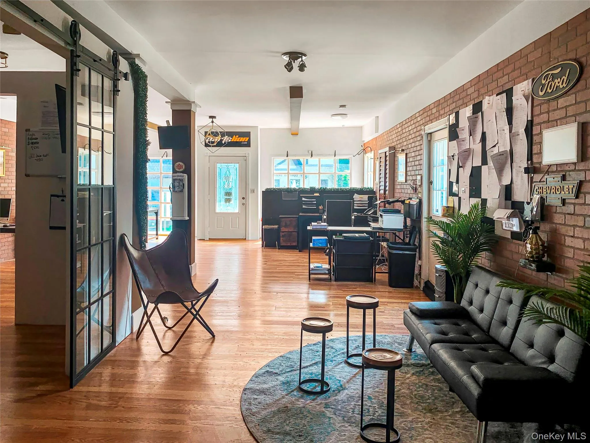 Living area featuring brick wall and wood finished floors Living area featuring brick wall and wood finished floors