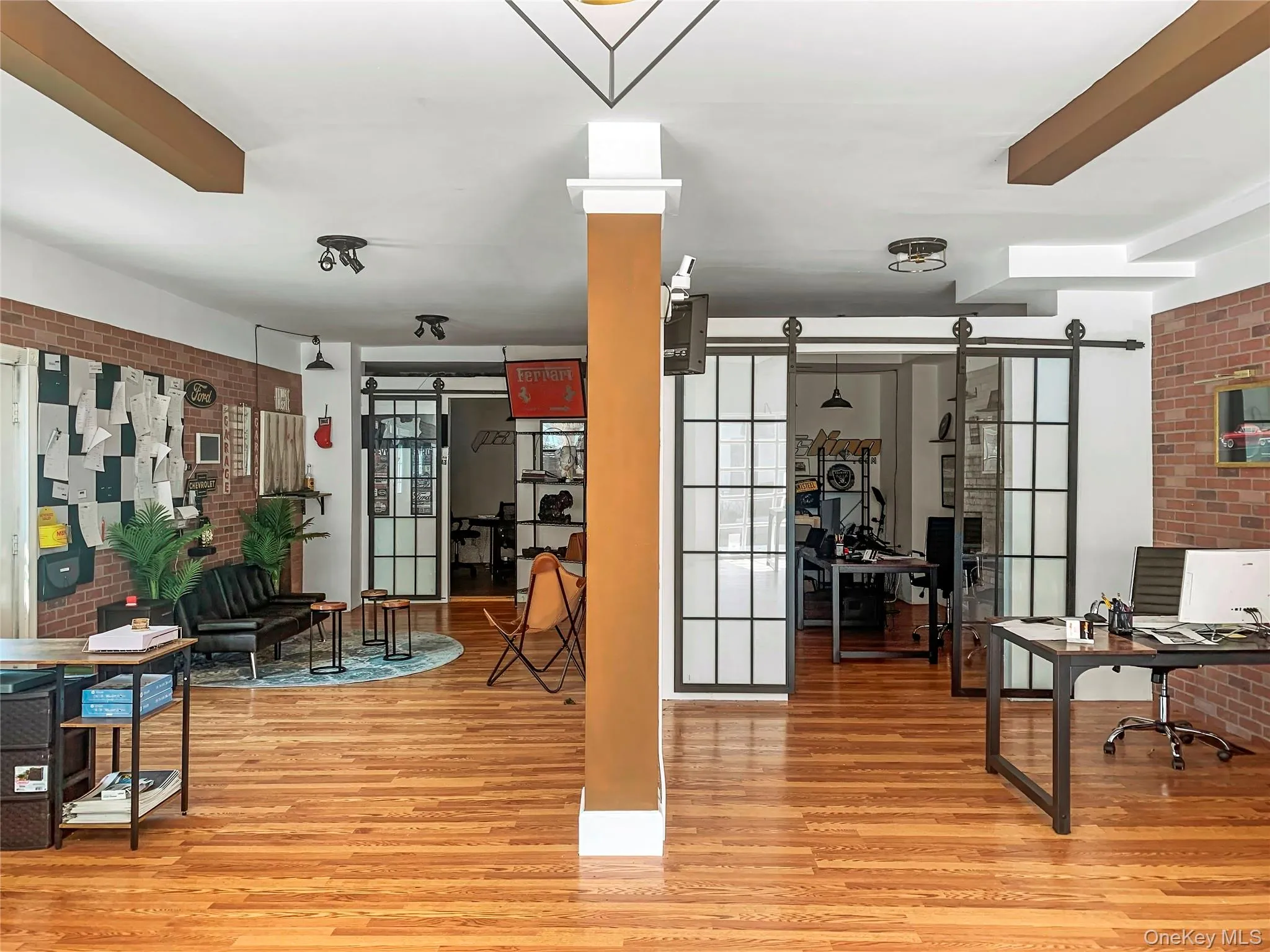 Exercise room featuring brick wall and light wood-style flooring Exercise room featuring brick wall and light wood-style flooring