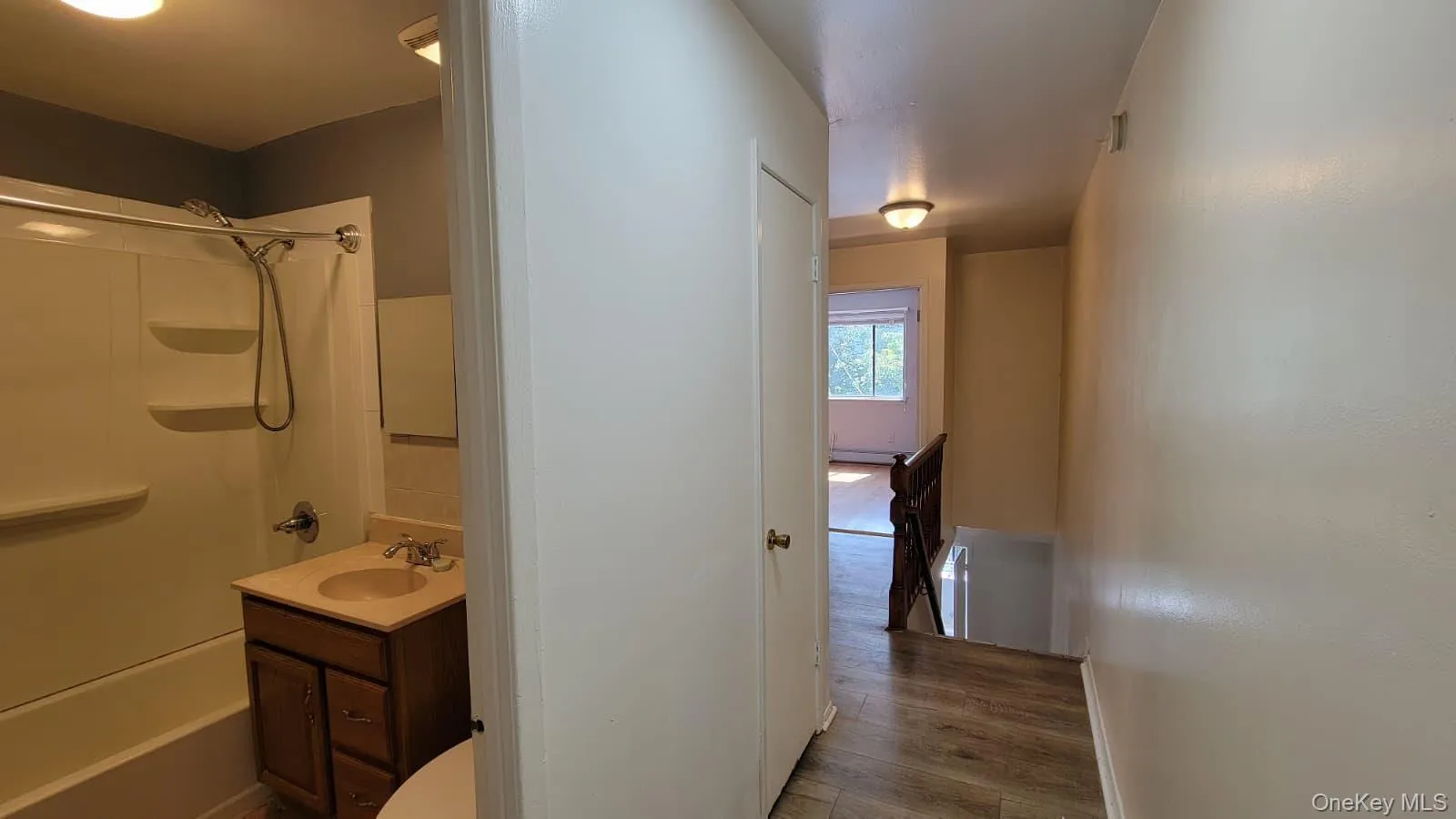 Full bath featuring bathtub / shower combination, vanity, and dark wood-style flooring Full bath featuring bathtub / shower combination, vanity, and dark wood-style flooring