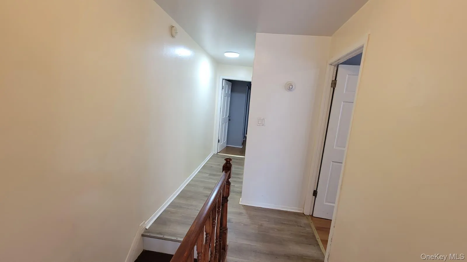 Hall featuring an upstairs landing and dark wood finished floors Hall featuring an upstairs landing and dark wood finished floors