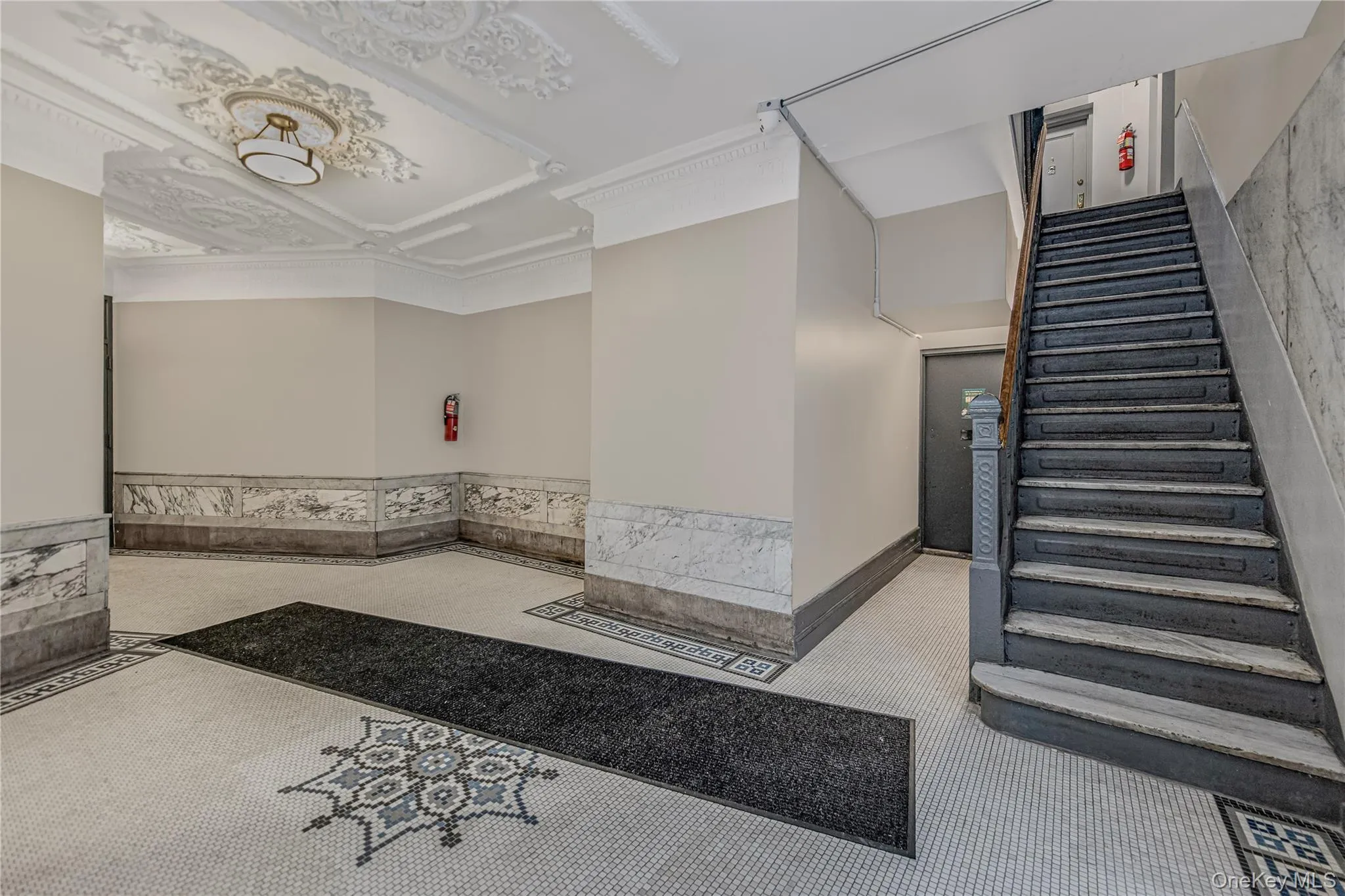 Lobby featuring stairs and wainscoting Lobby featuring stairs and wainscoting