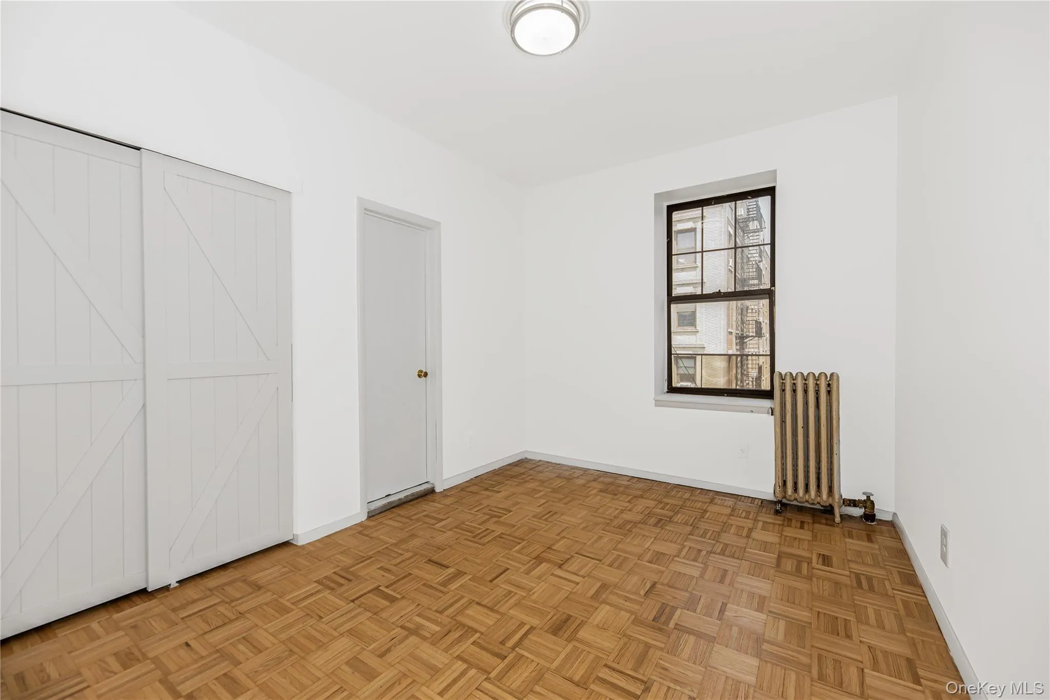 Unfurnished bedroom with radiator heating unit and baseboards Unfurnished bedroom with radiator heating unit and baseboards