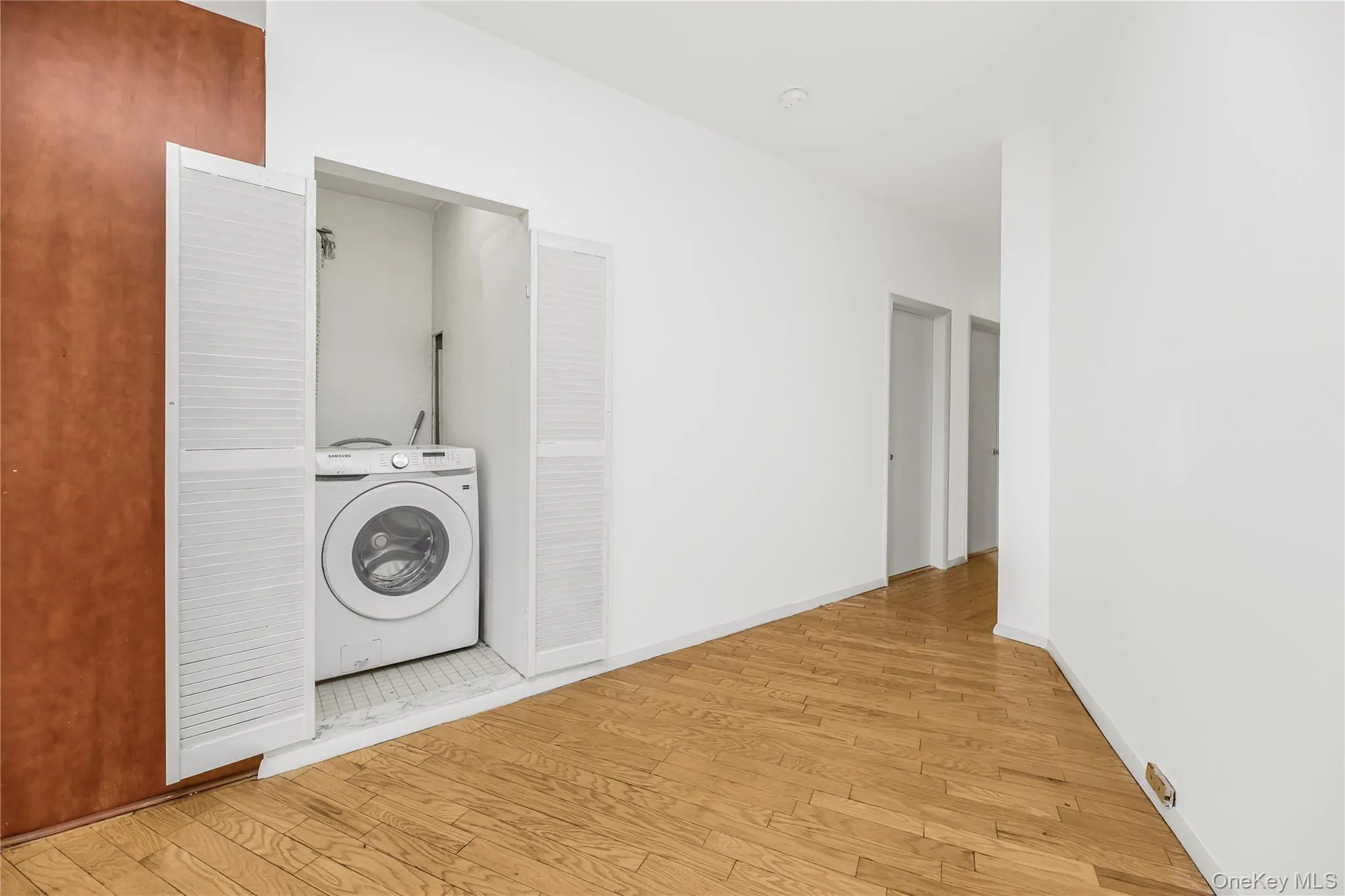 Washroom with washer / clothes dryer and wood finished floors Washroom with washer / clothes dryer and wood finished floors