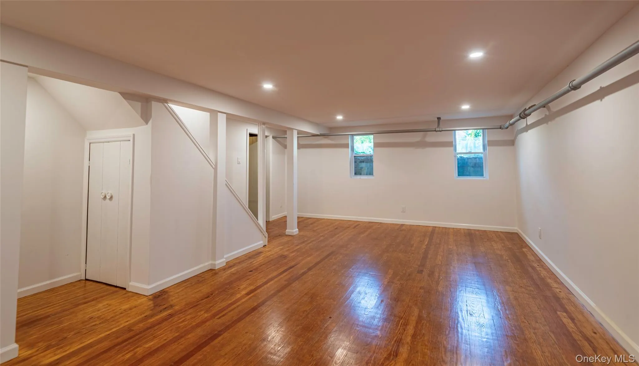 Basement featuring recessed lighting and hardwood / wood-style flooring Basement featuring recessed lighting and hardwood / wood-style flooring