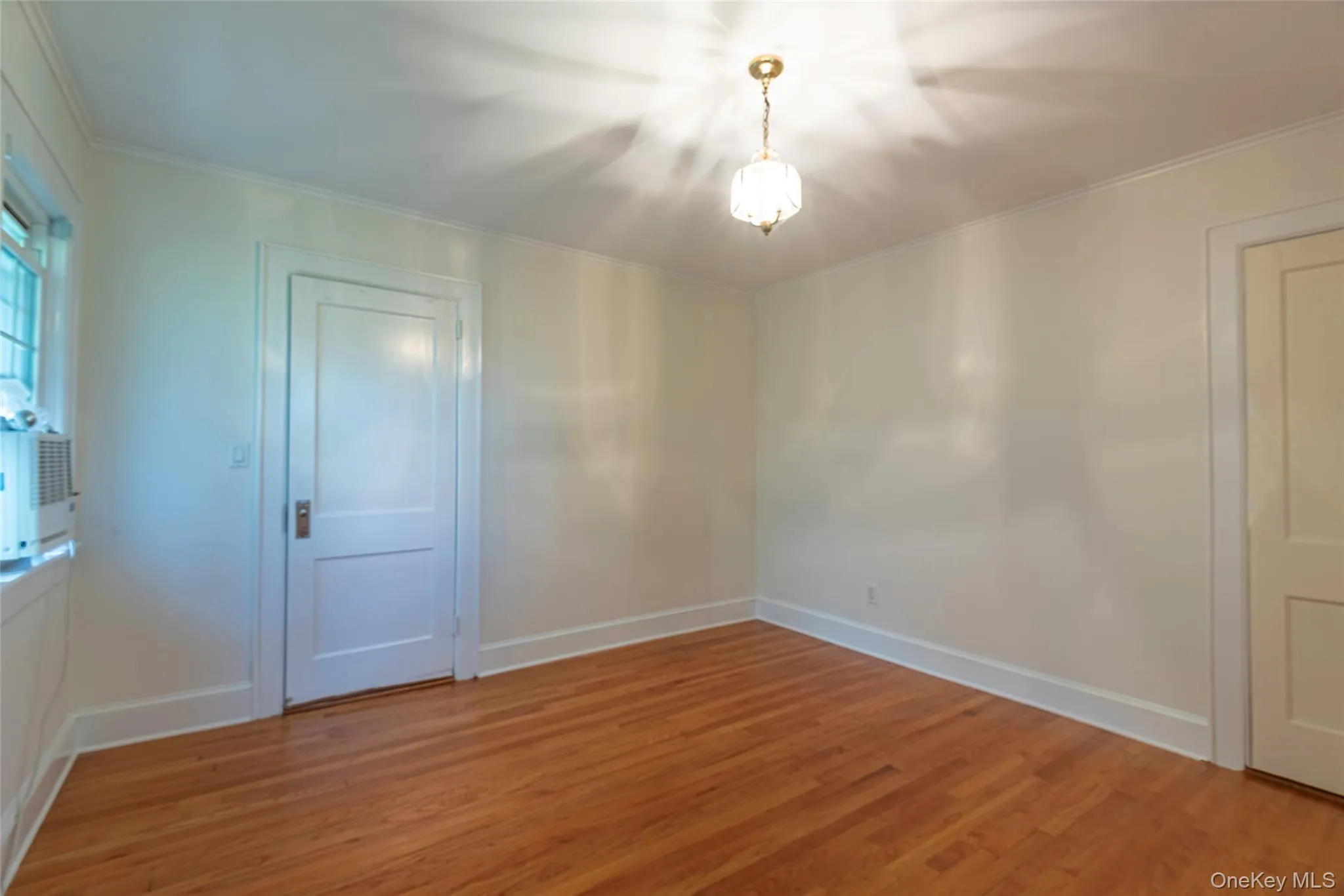 Spare room featuring light wood-style flooring and crown molding Spare room featuring light wood-style flooring and crown molding