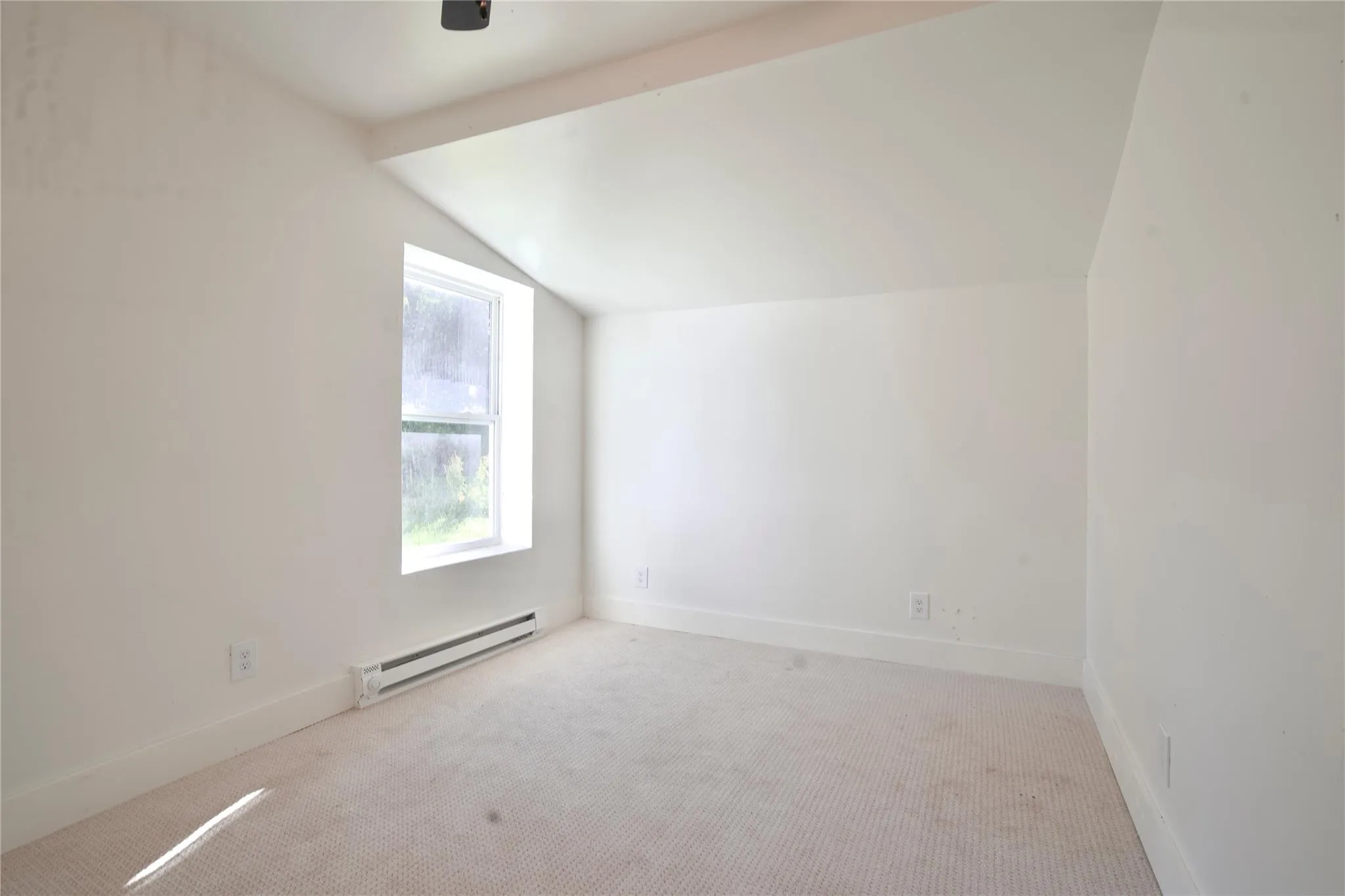 Additional living space featuring vaulted ceiling, baseboard heating, carpet flooring, and a ceiling fan Additional living space featuring vaulted ceiling, baseboard heating, carpet flooring, and a ceiling fan