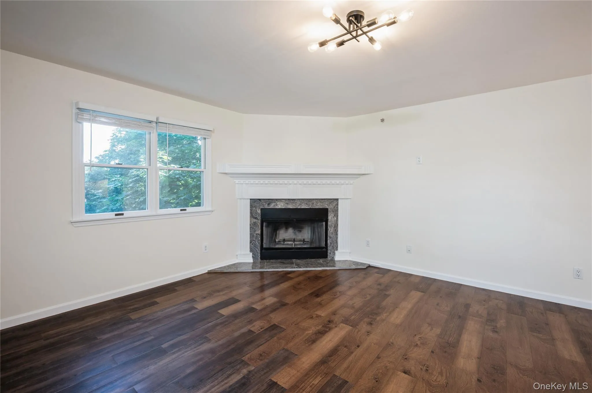 Another view of the spacious, bright, living room with a cozy wood burning fire place Another view of the spacious, bright, living room with a cozy wood burning fire place