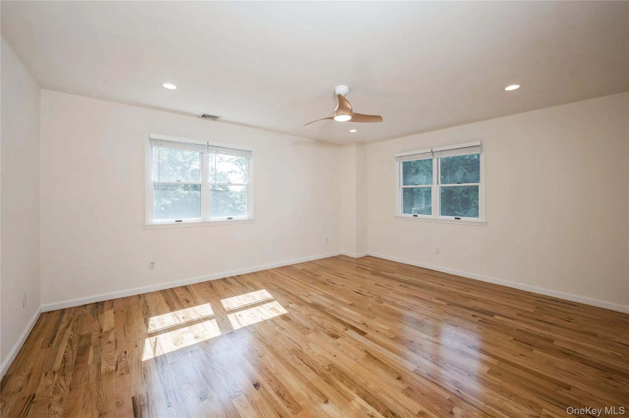 Another view of the sun filled primary bedroom, very spacious, ceiling fan, refinished hardwood flooring. Another view of the sun filled primary bedroom, very spacious, ceiling fan, refinished hardwood flooring.