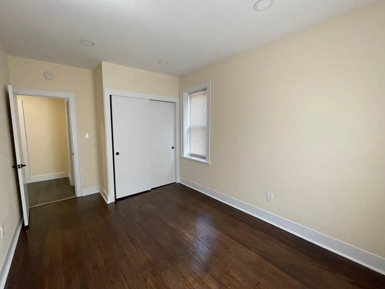 Unfurnished bedroom featuring dark wood-style floors and a closet Unfurnished bedroom featuring dark wood-style floors and a closet