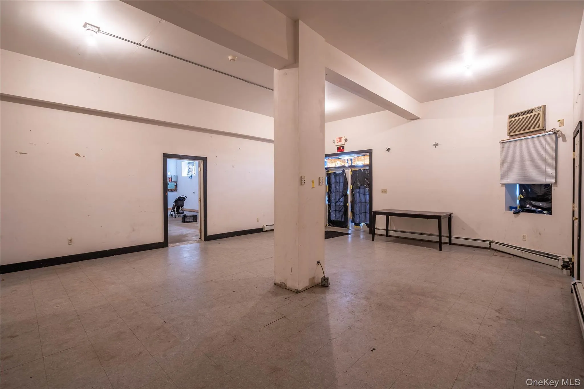 Garage with a baseboard heating unit and a wall unit AC Garage with a baseboard heating unit and a wall unit AC