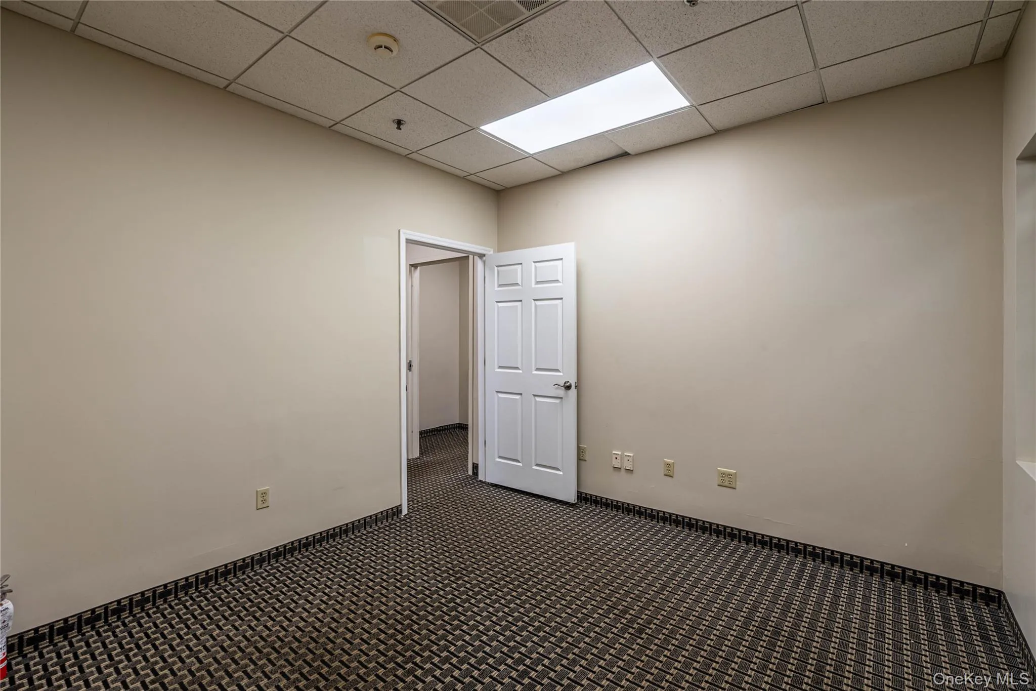 Spare room with dark carpet and a paneled ceiling Spare room with dark carpet and a paneled ceiling