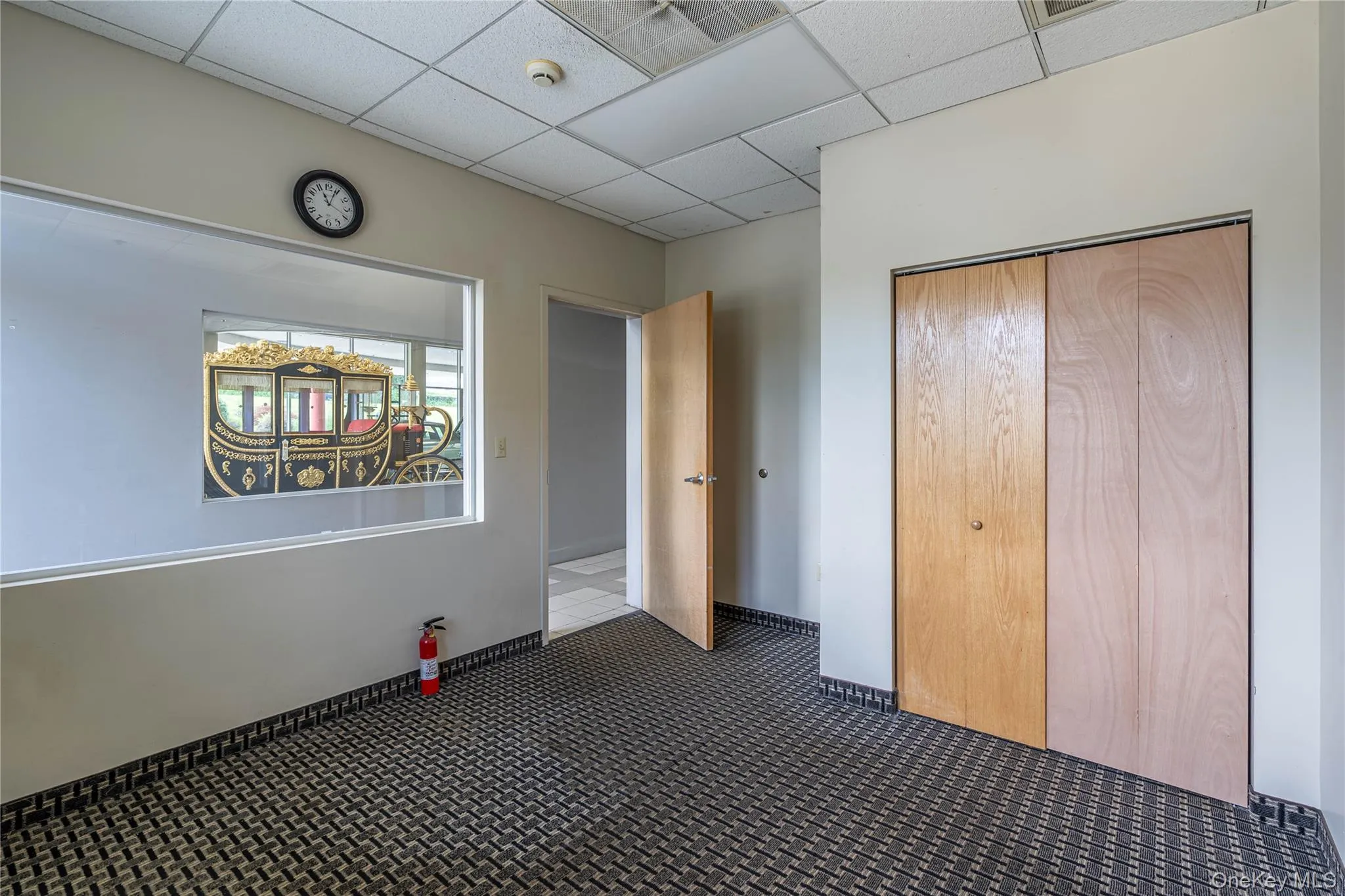 Unfurnished bedroom with carpet floors, a closet, and a paneled ceiling Unfurnished bedroom with carpet floors, a closet, and a paneled ceiling