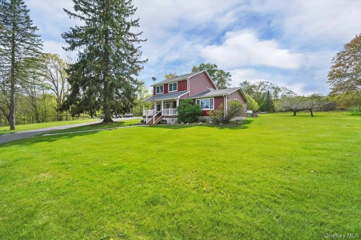 View of green lawn featuring a porch View of green lawn featuring a porch