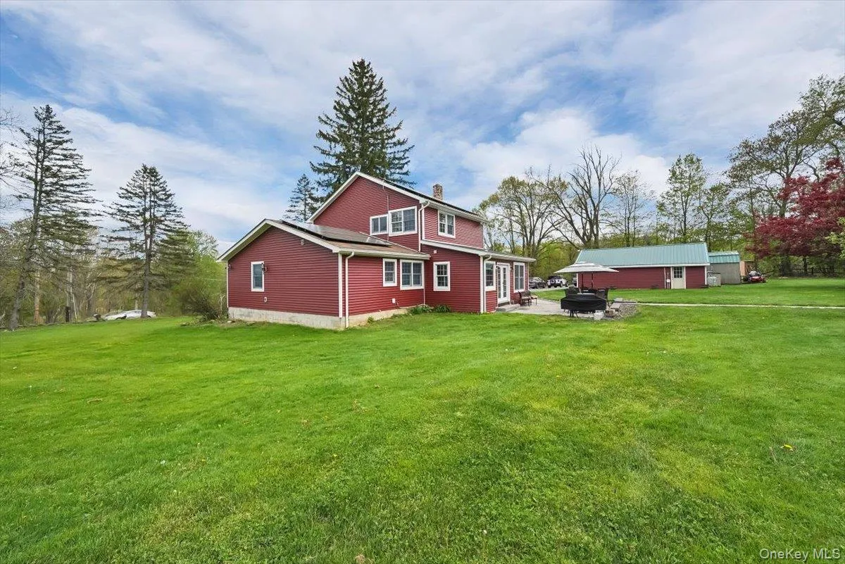 Rear view of house with a yard, a chimney, and a fire pit Rear view of house with a yard, a chimney, and a fire pit