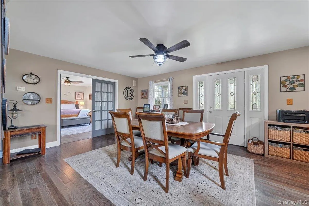 Dining area featuring dark wood-style floors, ceiling fan, and french doors Dining area featuring dark wood-style floors, ceiling fan, and french doors