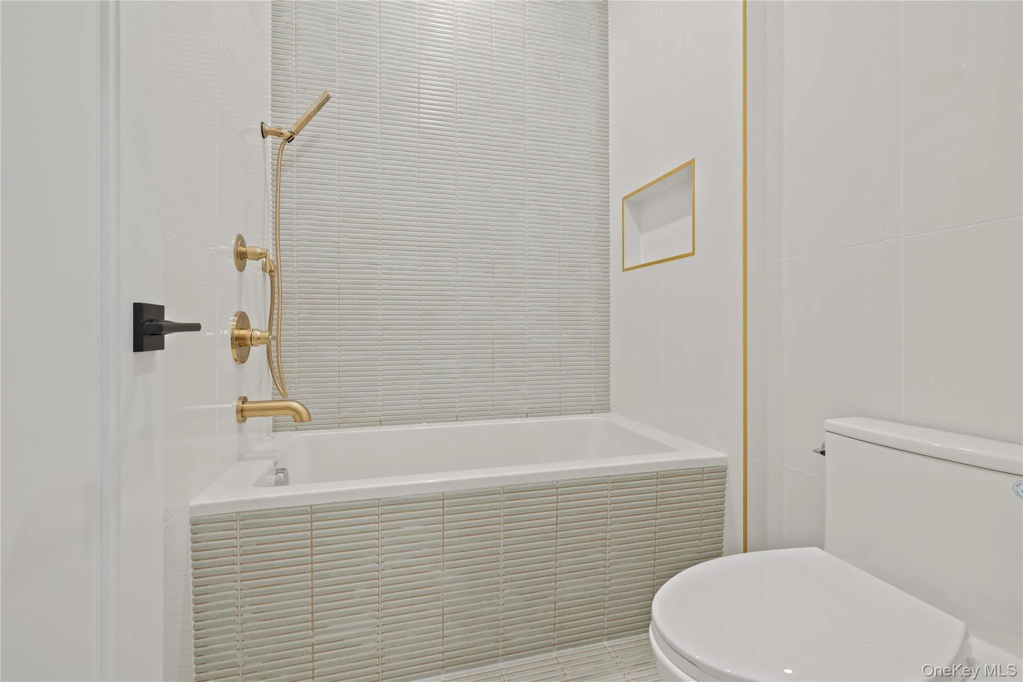 Bathroom with tiled shower / bath combo and tile walls Bathroom with tiled shower / bath combo and tile walls