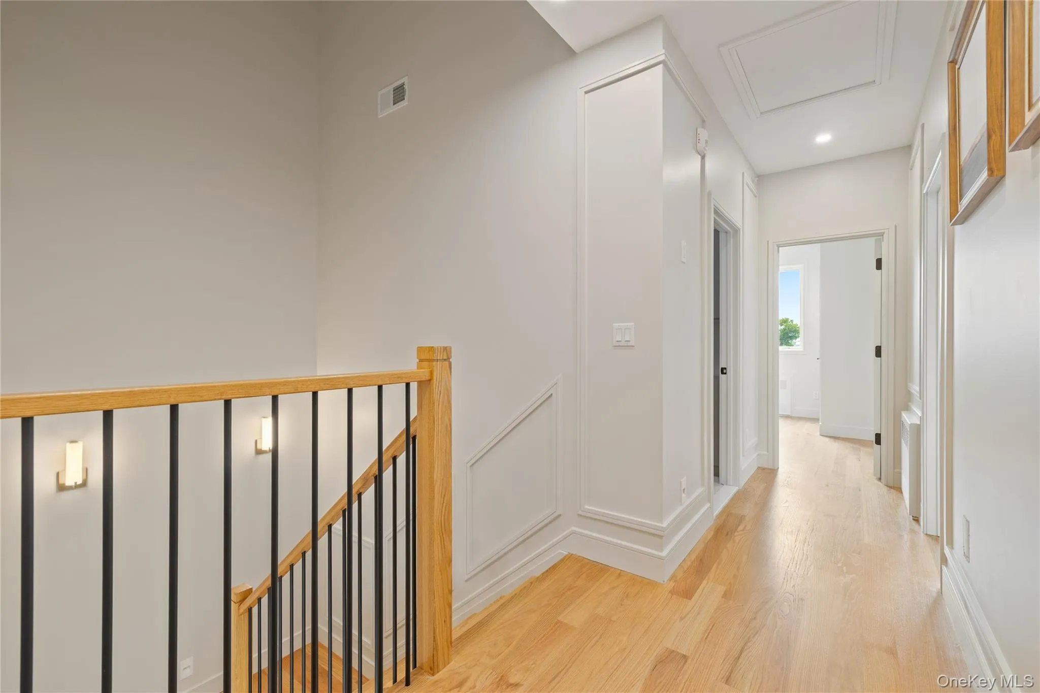 Hall featuring wood finished floors, an upstairs landing, and recessed lighting Hall featuring wood finished floors, an upstairs landing, and recessed lighting