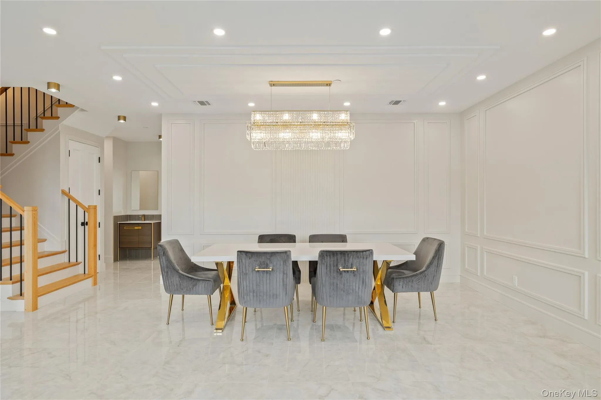 Dining area featuring a decorative wall, recessed lighting, stairs, and light marble finish floors Dining area featuring a decorative wall, recessed lighting, stairs, and light marble finish floors