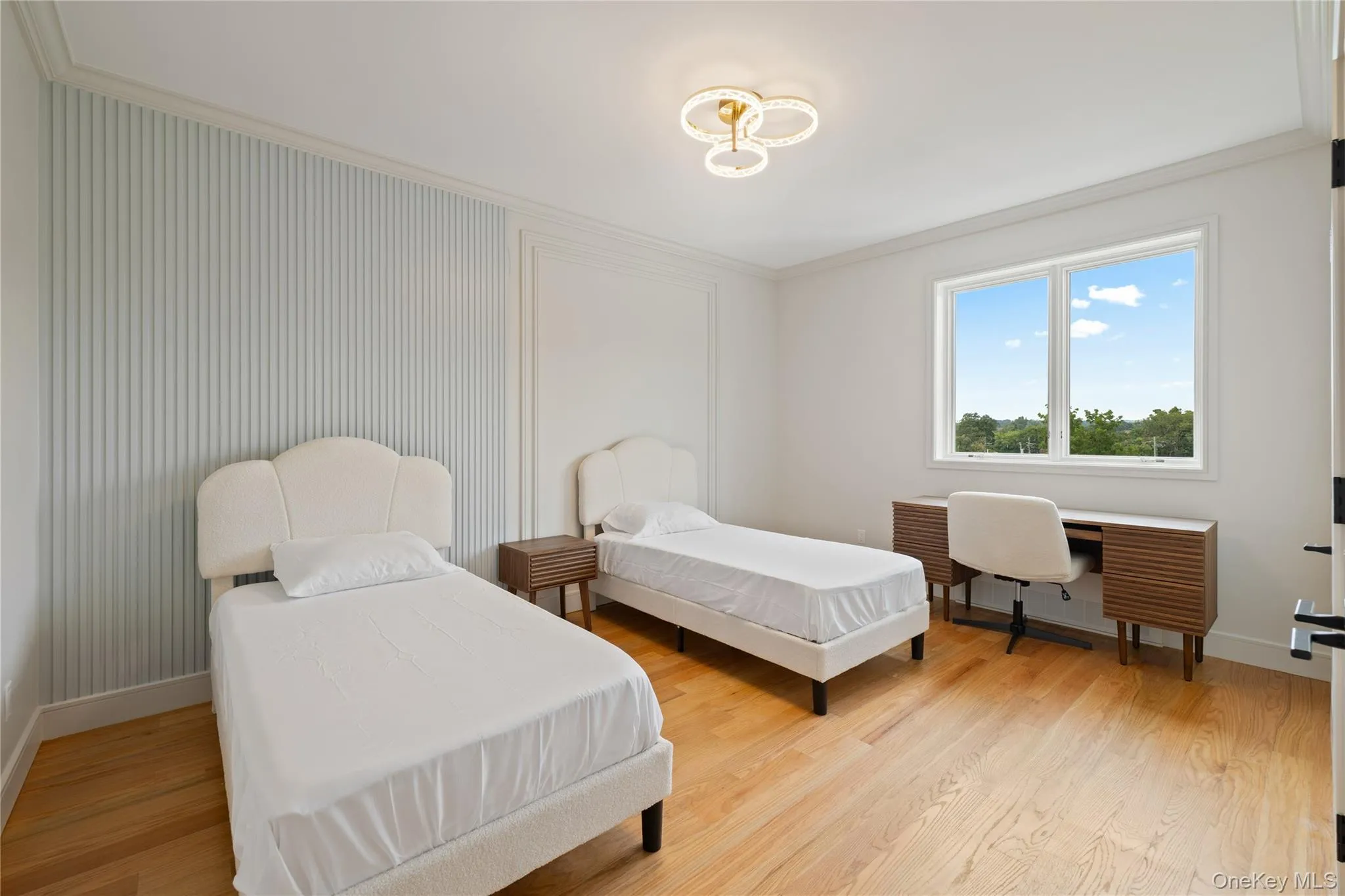 Bedroom with ornamental molding, light wood finished floors, and an office area Bedroom with ornamental molding, light wood finished floors, and an office area