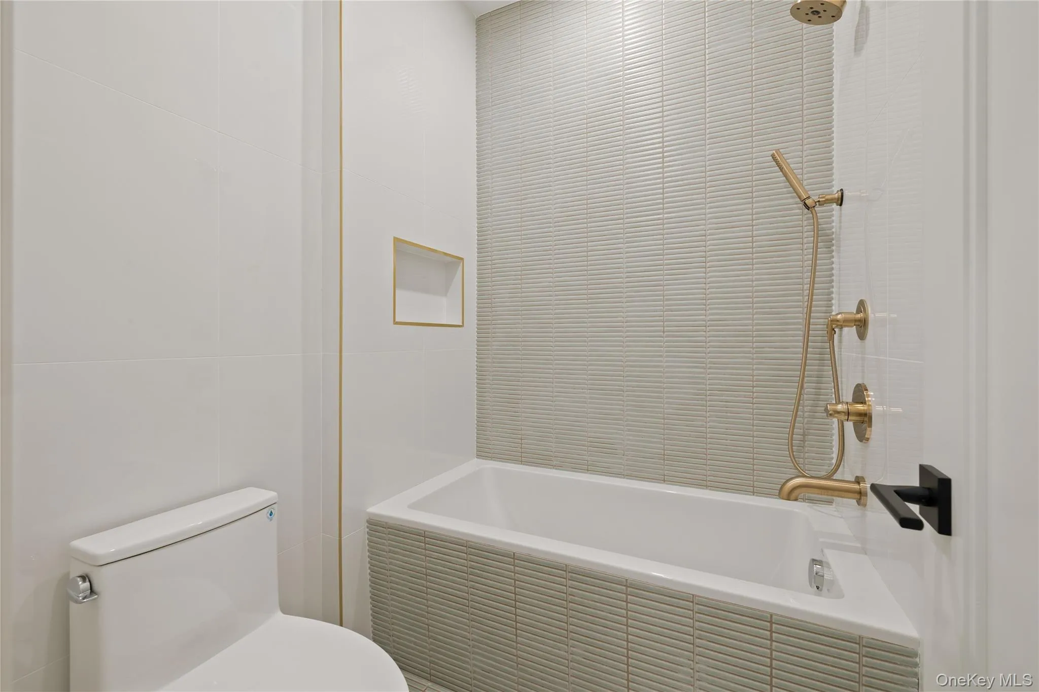 Full bath featuring tile walls and tiled shower / bath Full bath featuring tile walls and tiled shower / bath