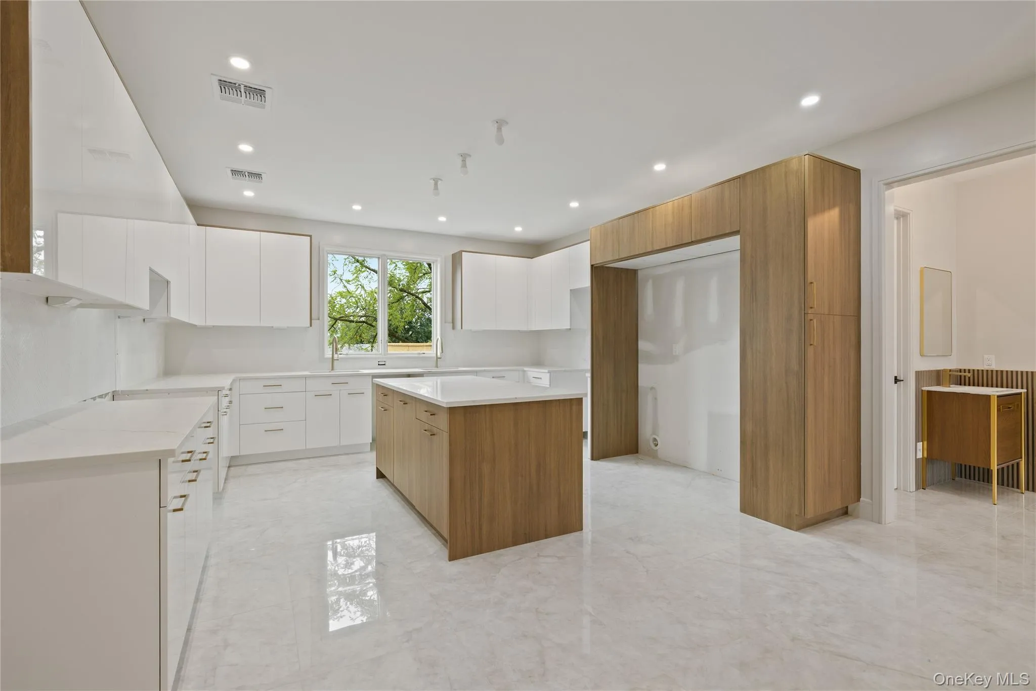 Kitchen featuring modern cabinets, a center island, light marble finish floors, and recessed lighting Kitchen featuring modern cabinets, a center island, light marble finish floors, and recessed lighting