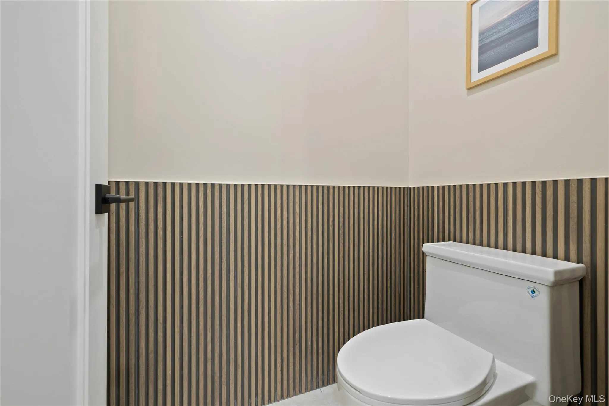 Half bath with a wainscoted wall and toilet Half bath with a wainscoted wall and toilet