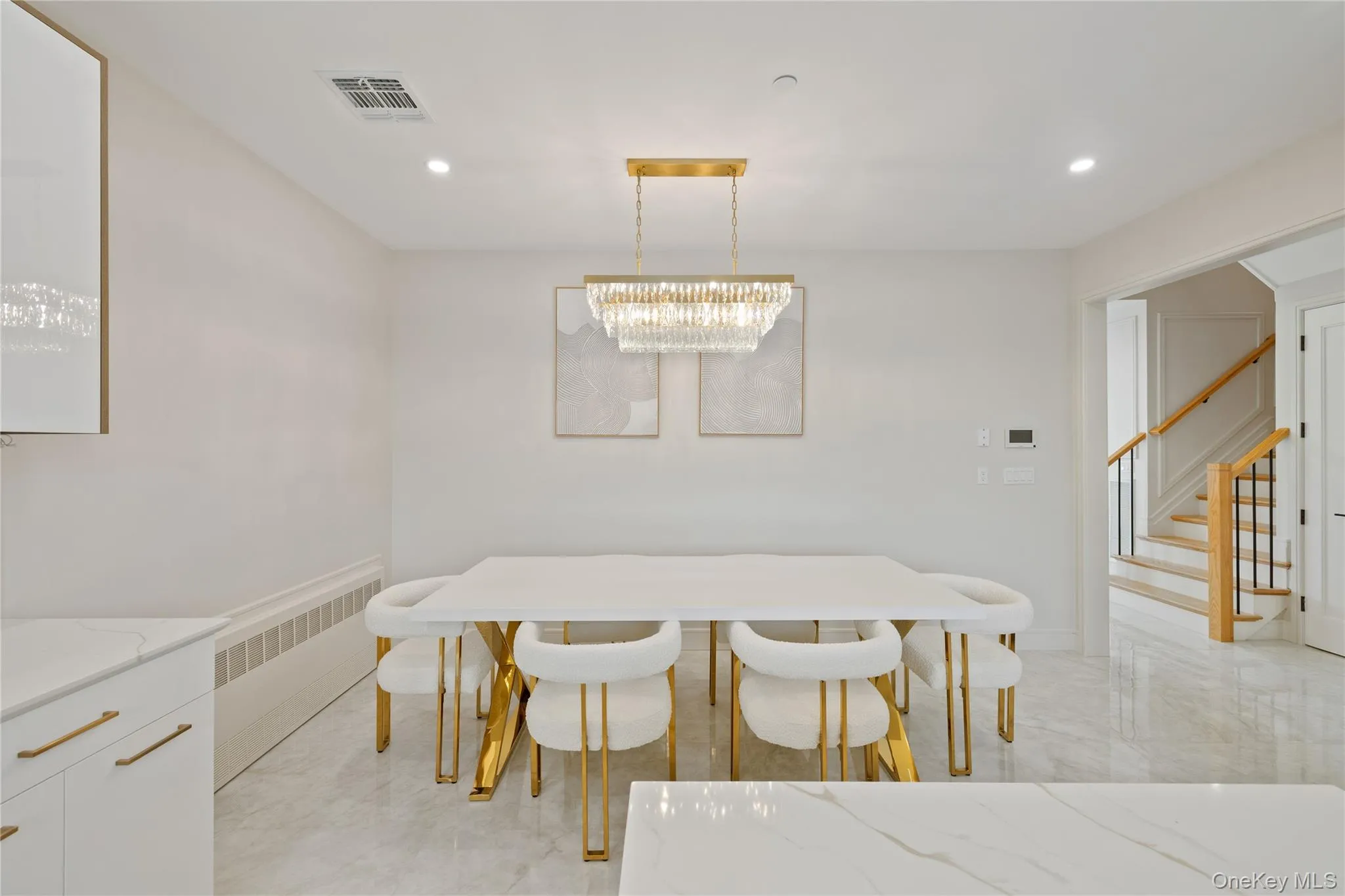 Dining room with recessed lighting, stairs, radiator, a chandelier, and light marble finish flooring Dining room with recessed lighting, stairs, radiator, a chandelier, and light marble finish flooring