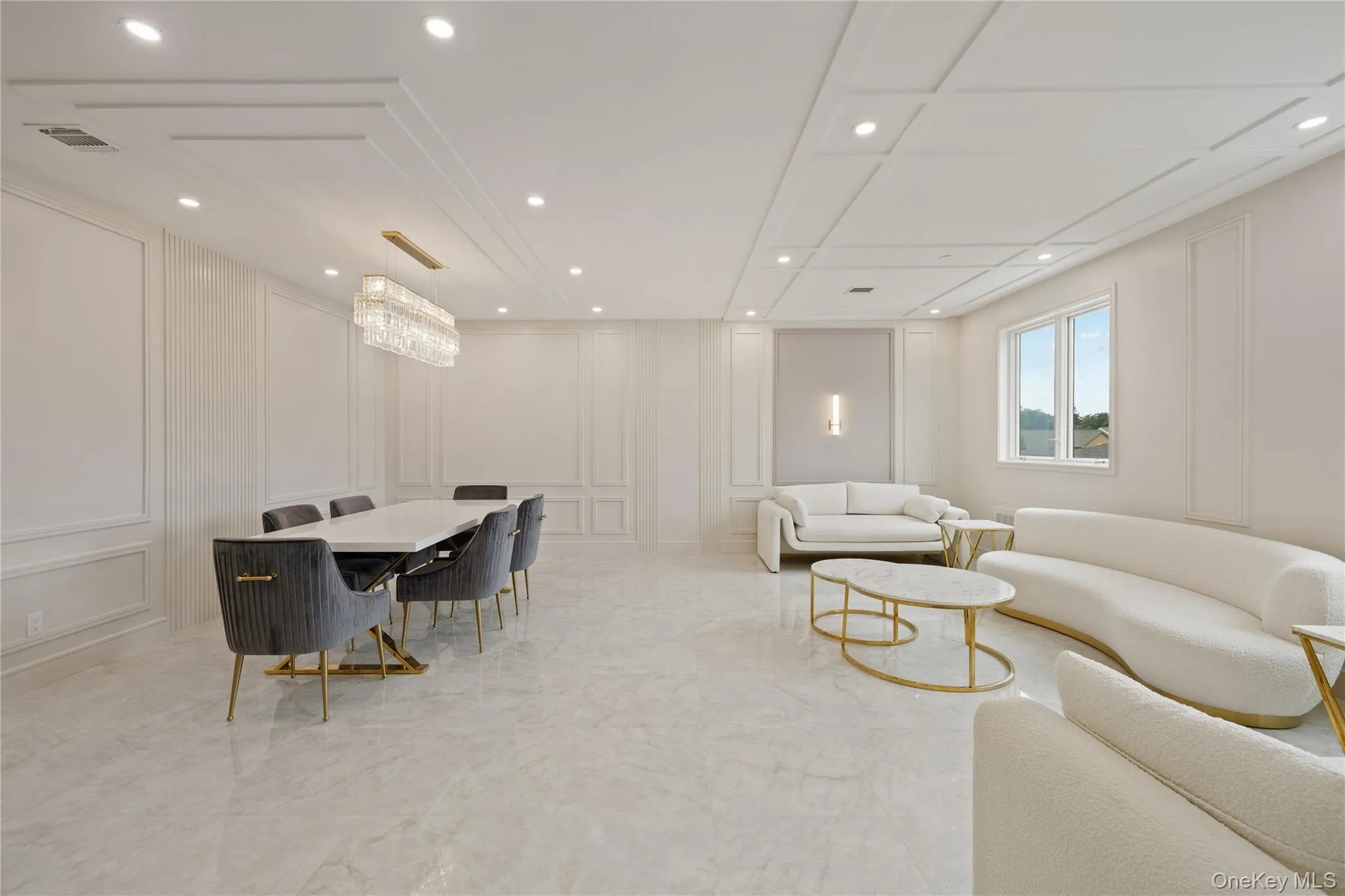 Living area with a decorative wall, recessed lighting, and light marble finish flooring Living area with a decorative wall, recessed lighting, and light marble finish flooring