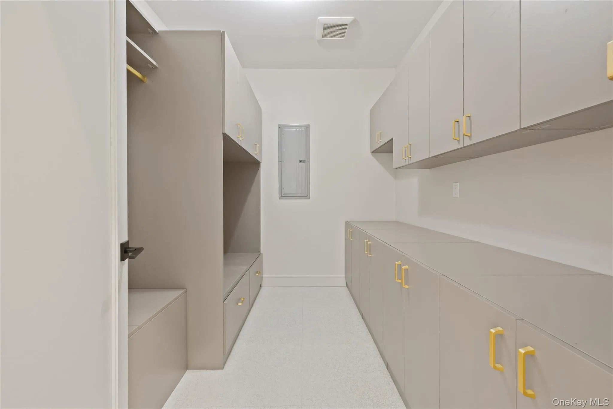 Walk in closet with electric panel and light colored carpet Walk in closet with electric panel and light colored carpet